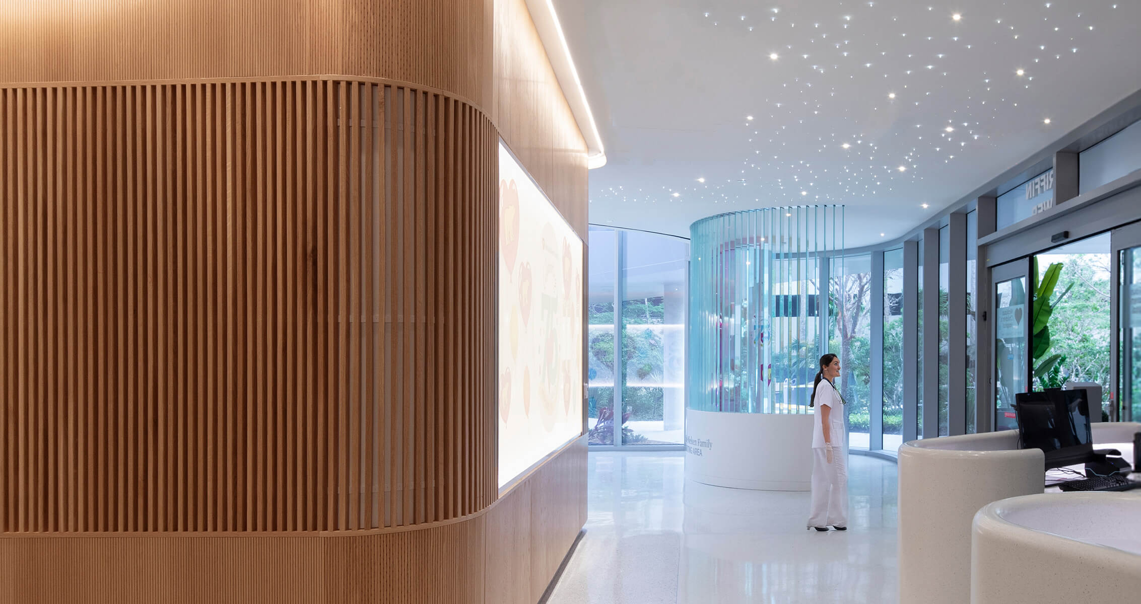Curved wood and glass walls and a ceiling with sparkling light feature in a hospital interior