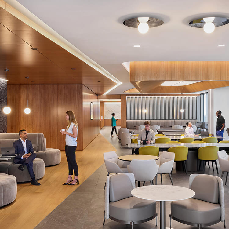 Modern office cafeteria with stylish seating and professionals collaborating.