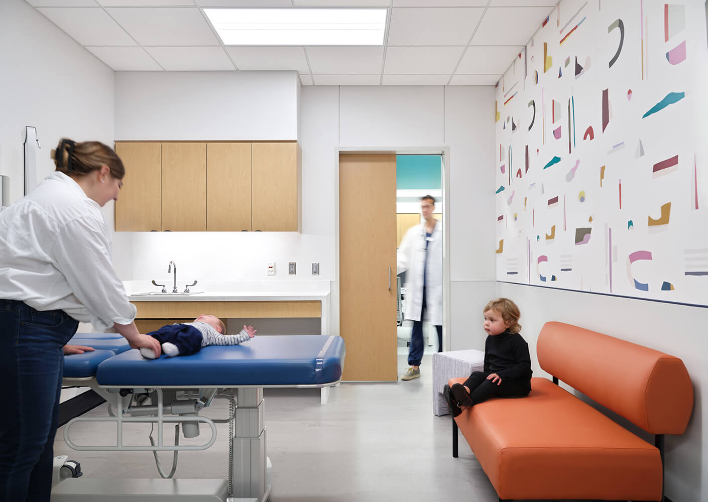 Pediatric clinic interior with children, parent, and doctor in a modern, colorful setting.
