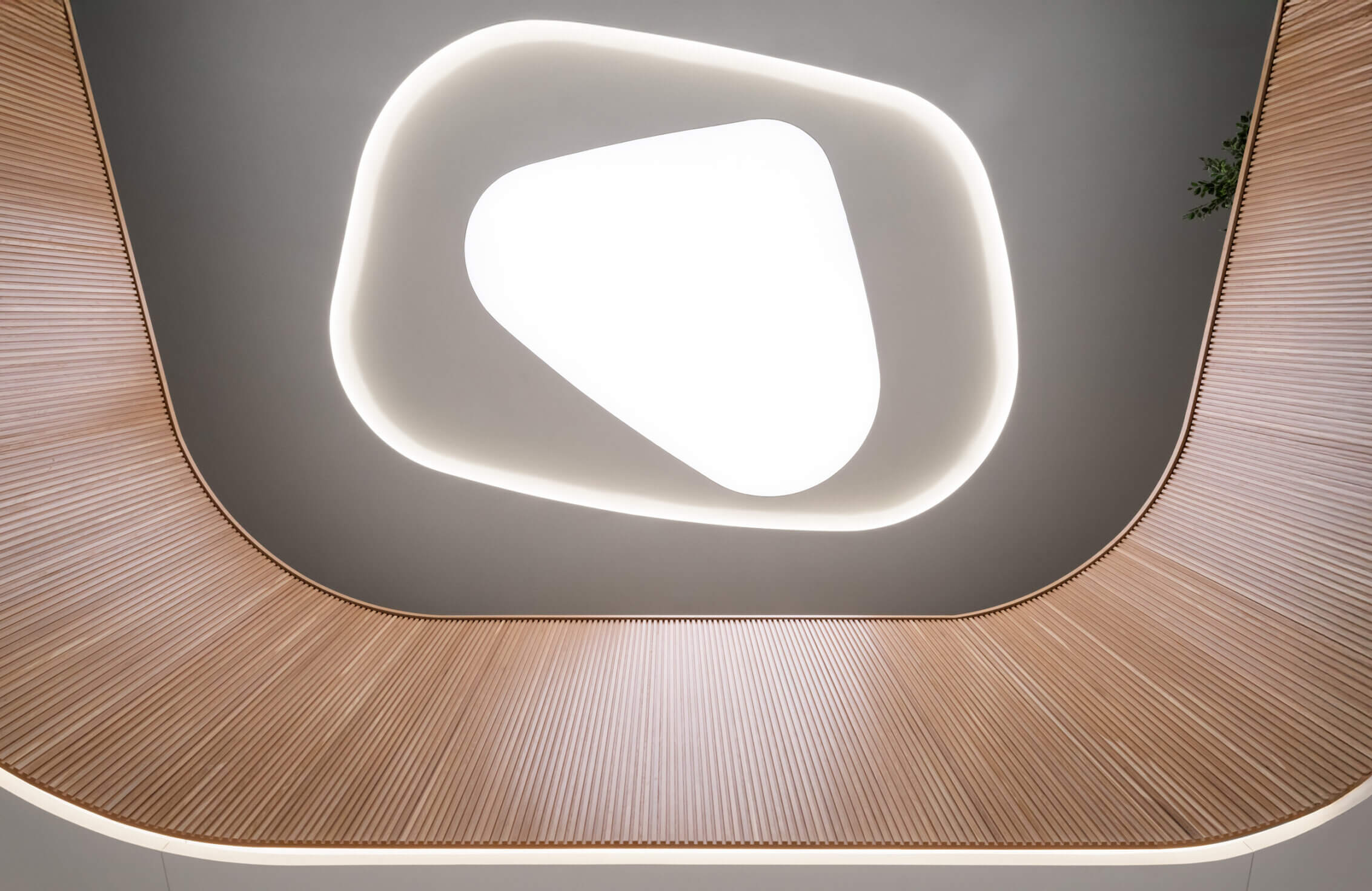 Modern abstract ceiling design with wood panel accents and soft lighting.