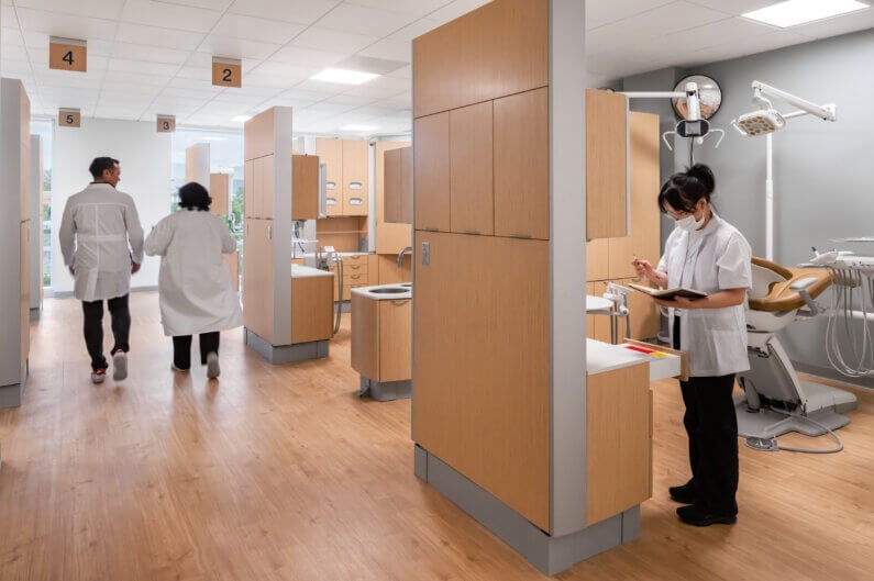 Dentist clinic with staff, dental chairs, and equipment in bright, modern interior.