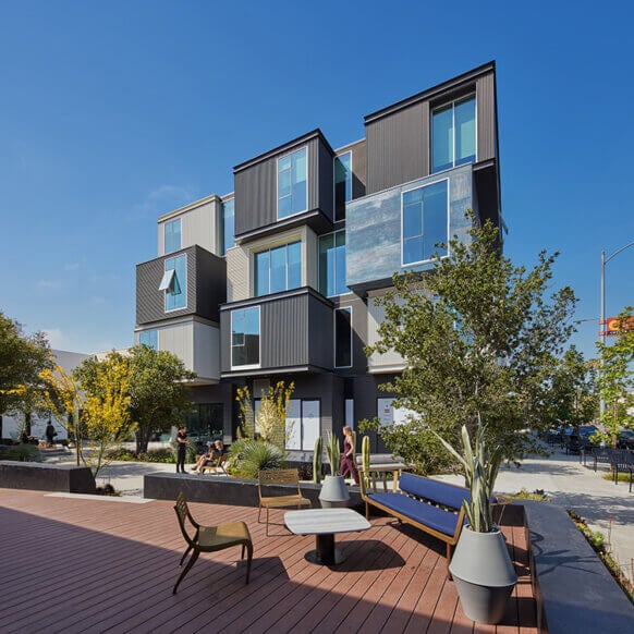Modern building with geometric design and outdoor seating area.