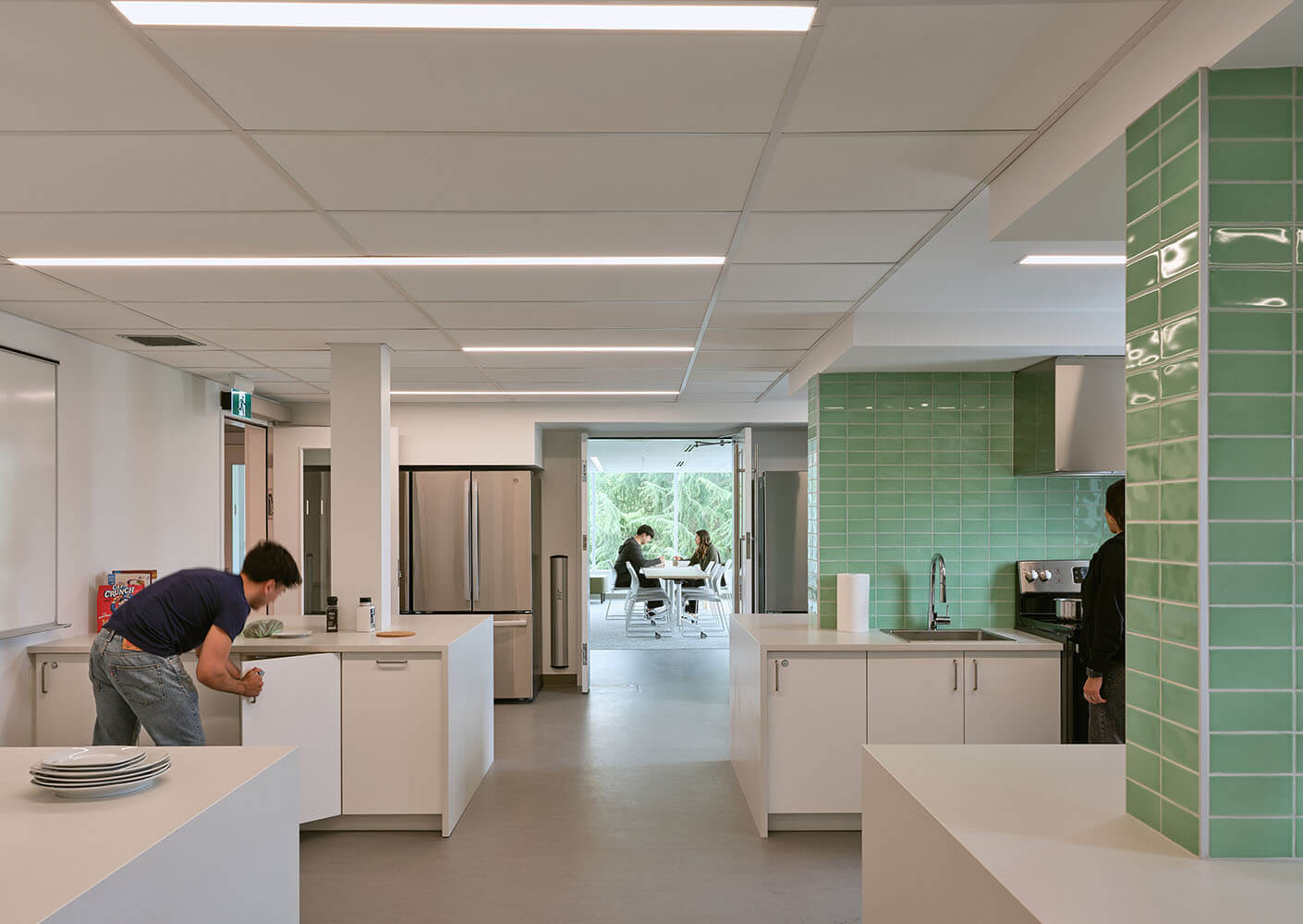 Modern kitchen space with people working and meeting in a bright, open design.