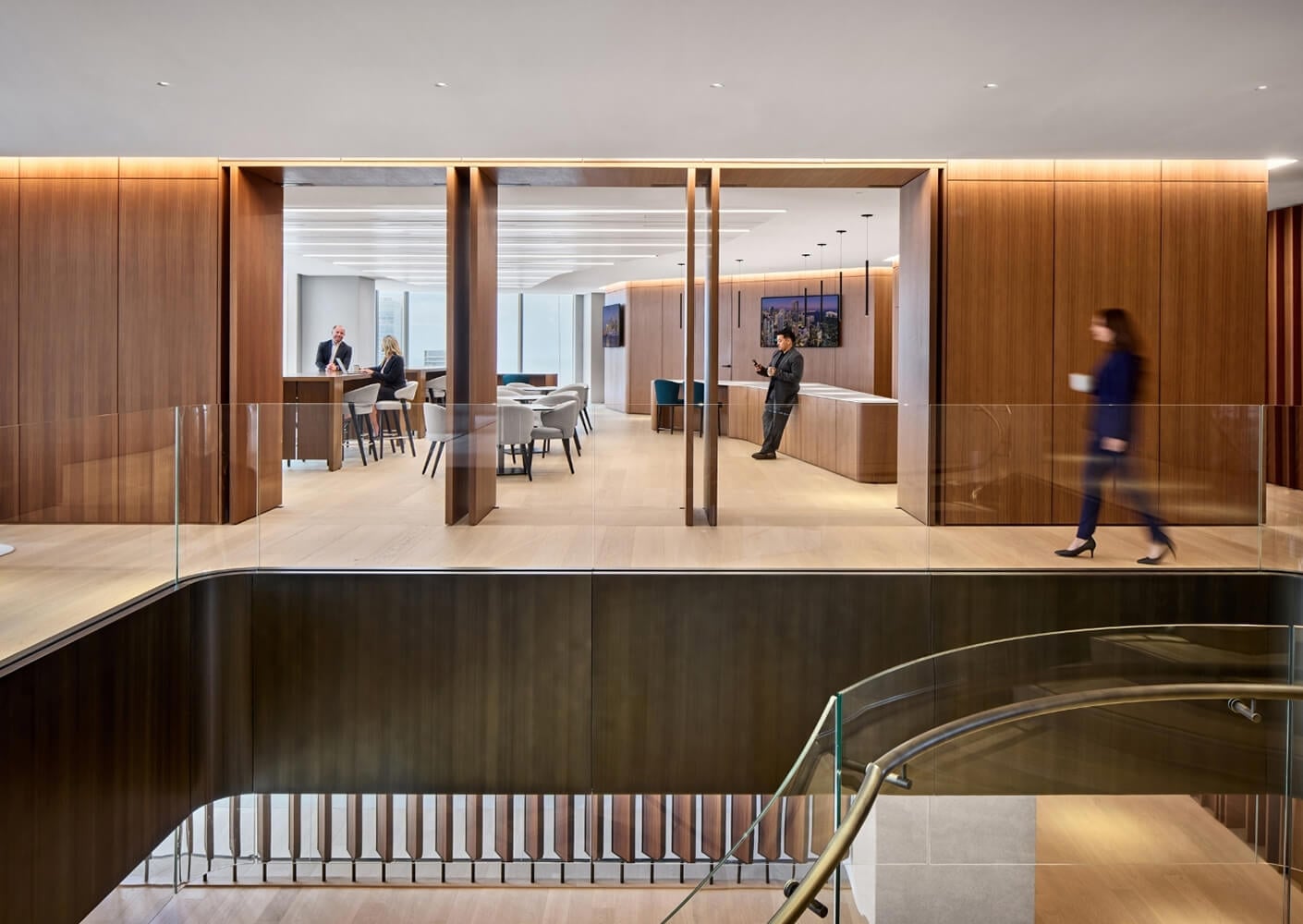 Spacious modern office lobby with people and wood paneling.