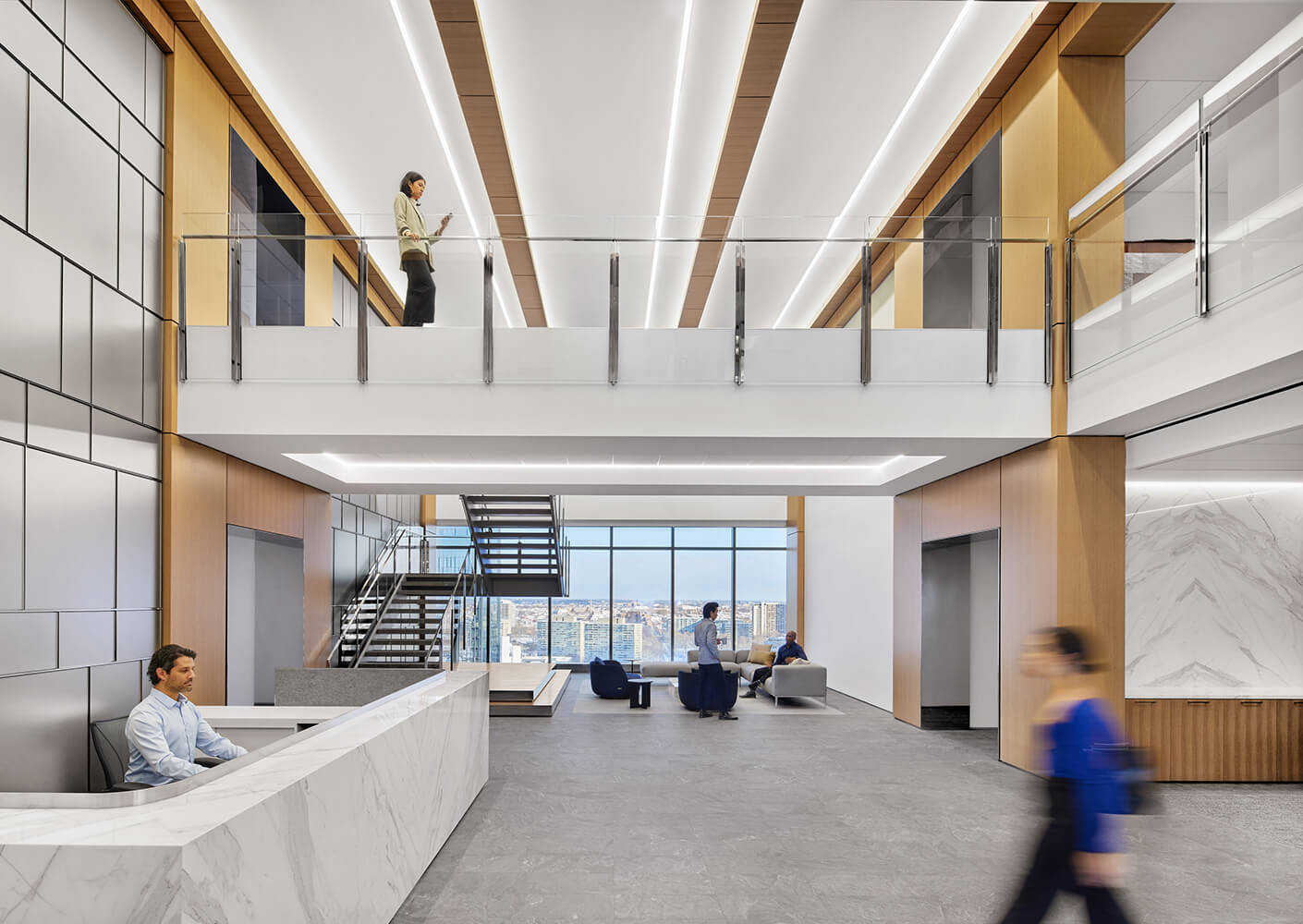 Modern office lobby with people, stairs, and natural light.