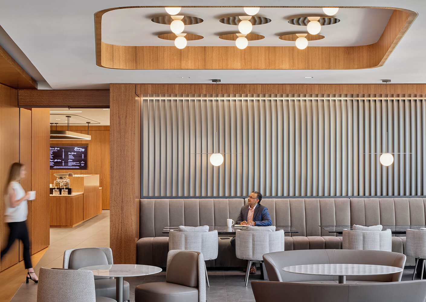 Modern cafe interior with wood accents, seating, and stylish lighting.