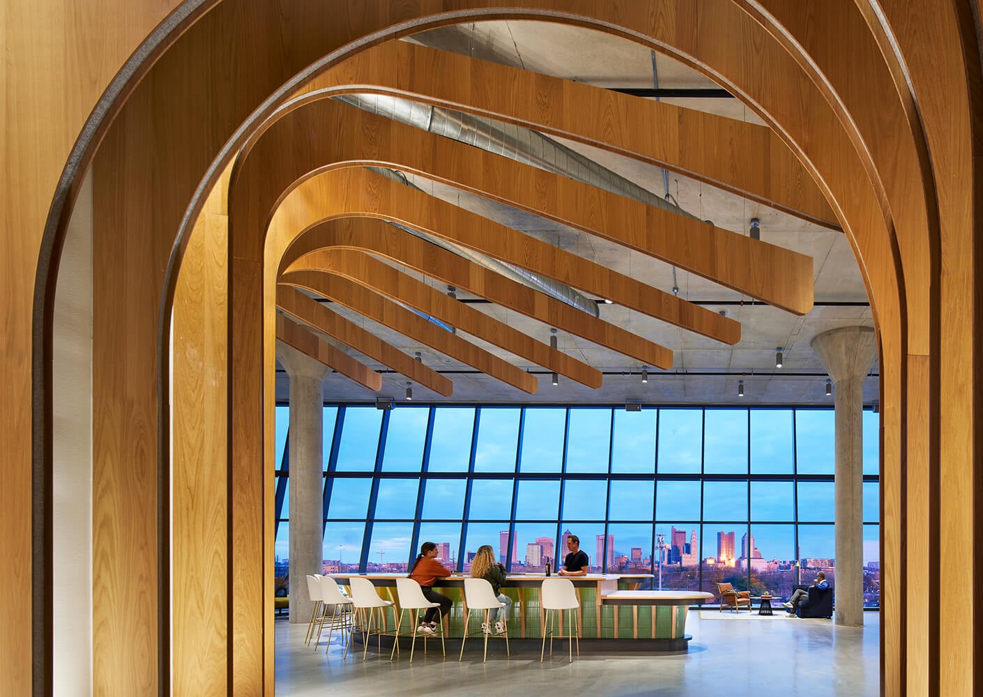 Modern office interior with arched wood design and city view.