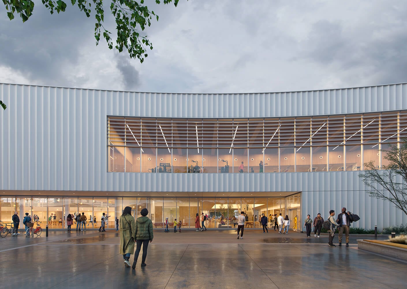 Modern building facade with large windows and people walking outside on a cloudy day.