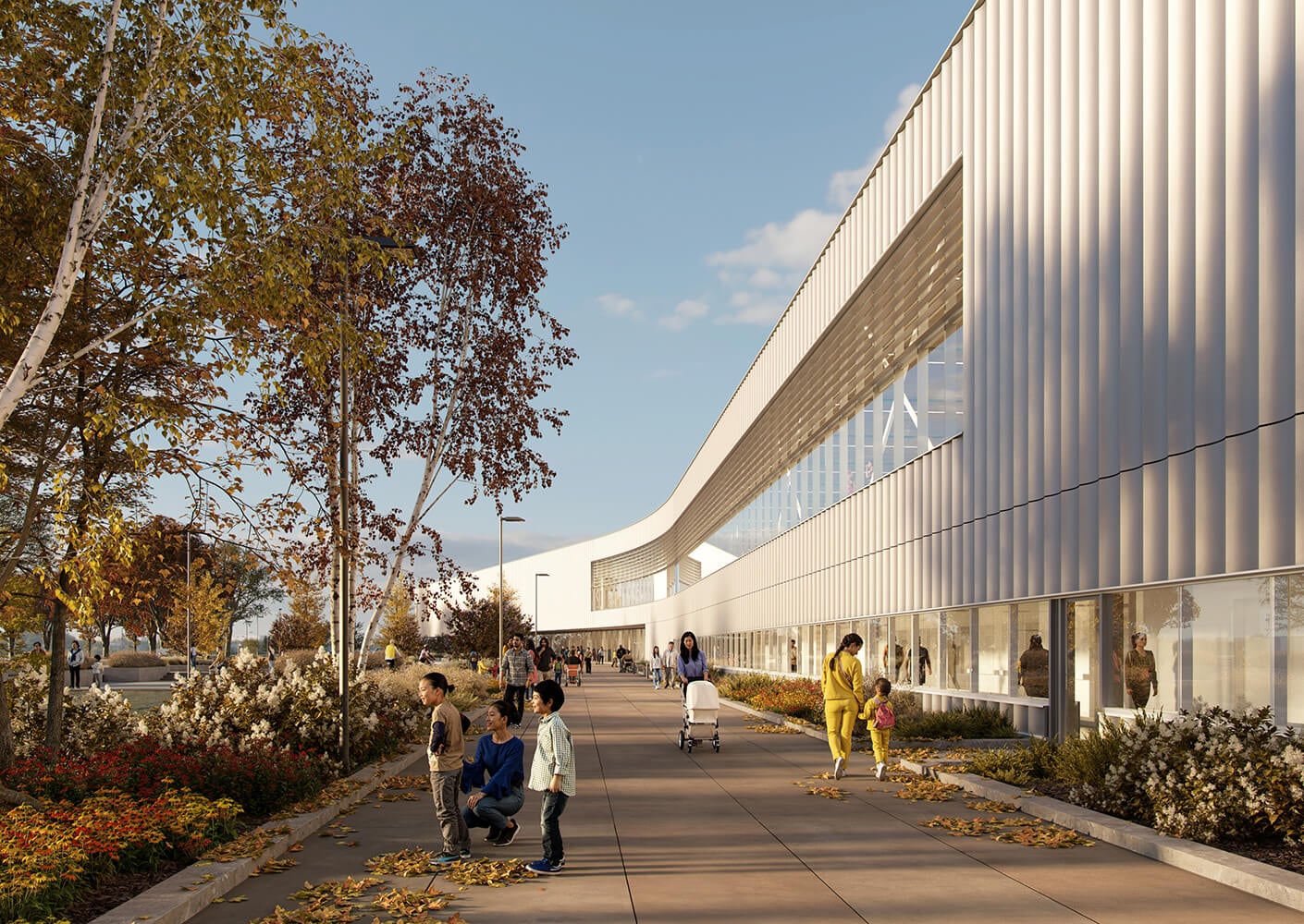 Modern building with people on a tree-lined walkway, under a clear blue sky.