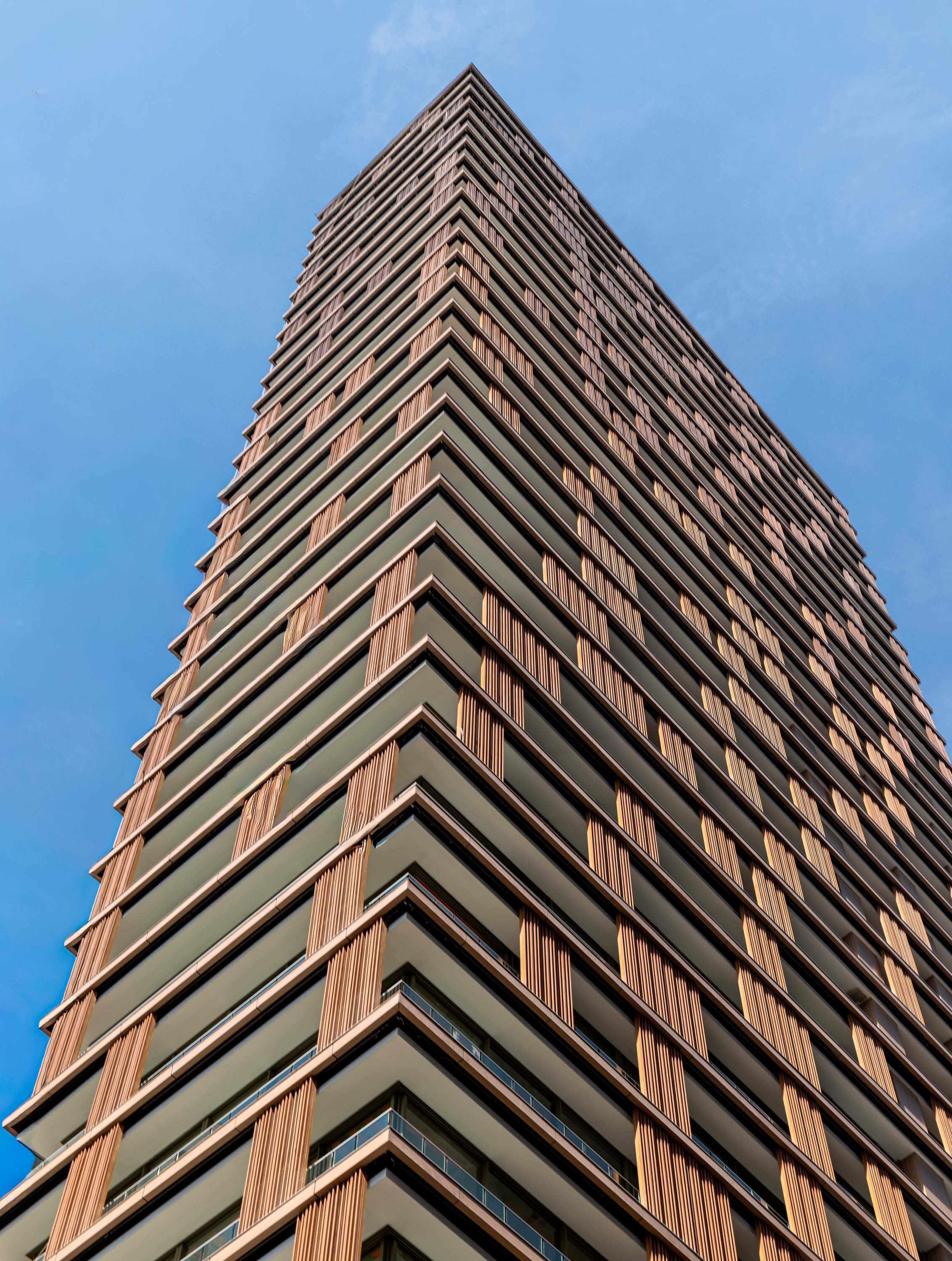 Modern high-rise building against clear blue sky.