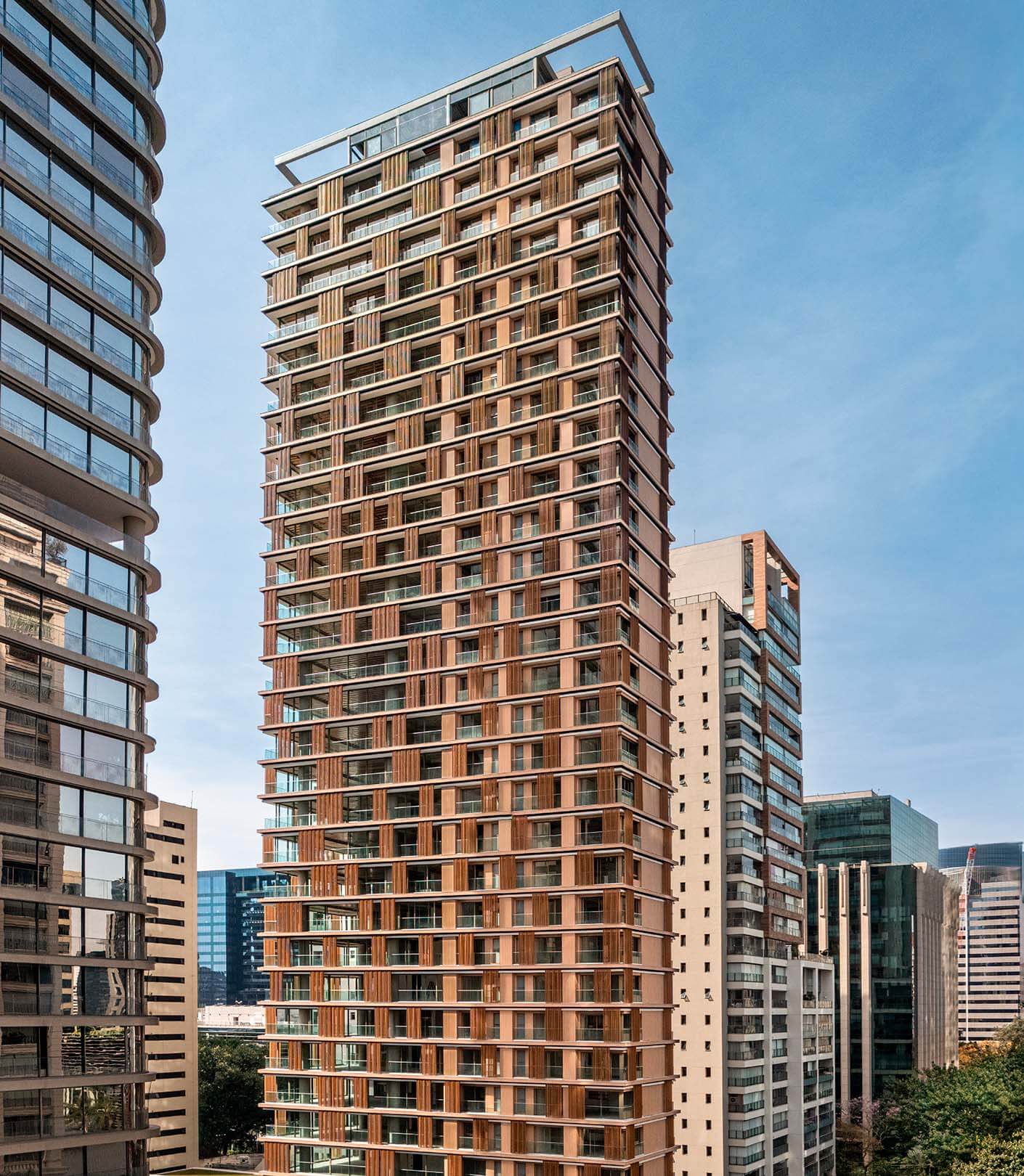 Modern high-rise building against blue sky in urban setting.