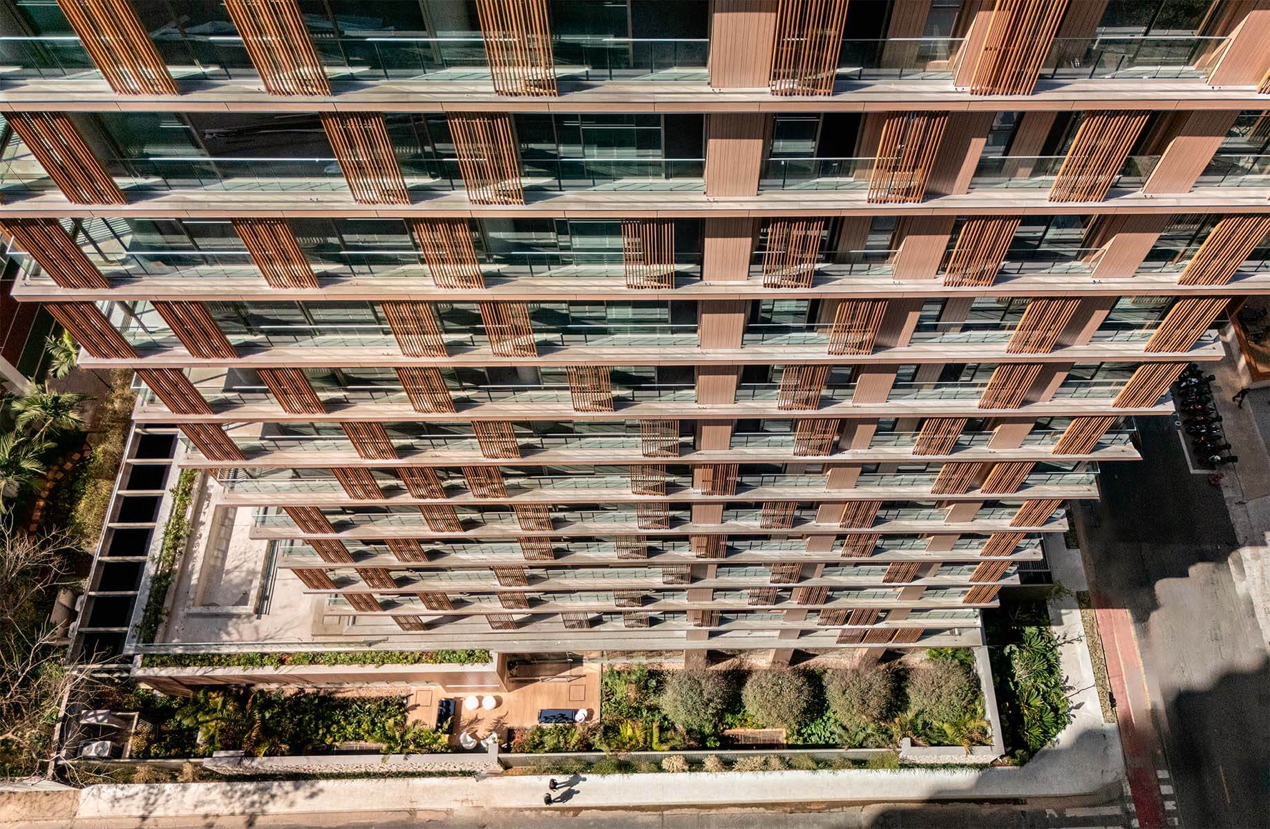 Aerial view of modern building exterior with vertical wood accents and green landscaping.