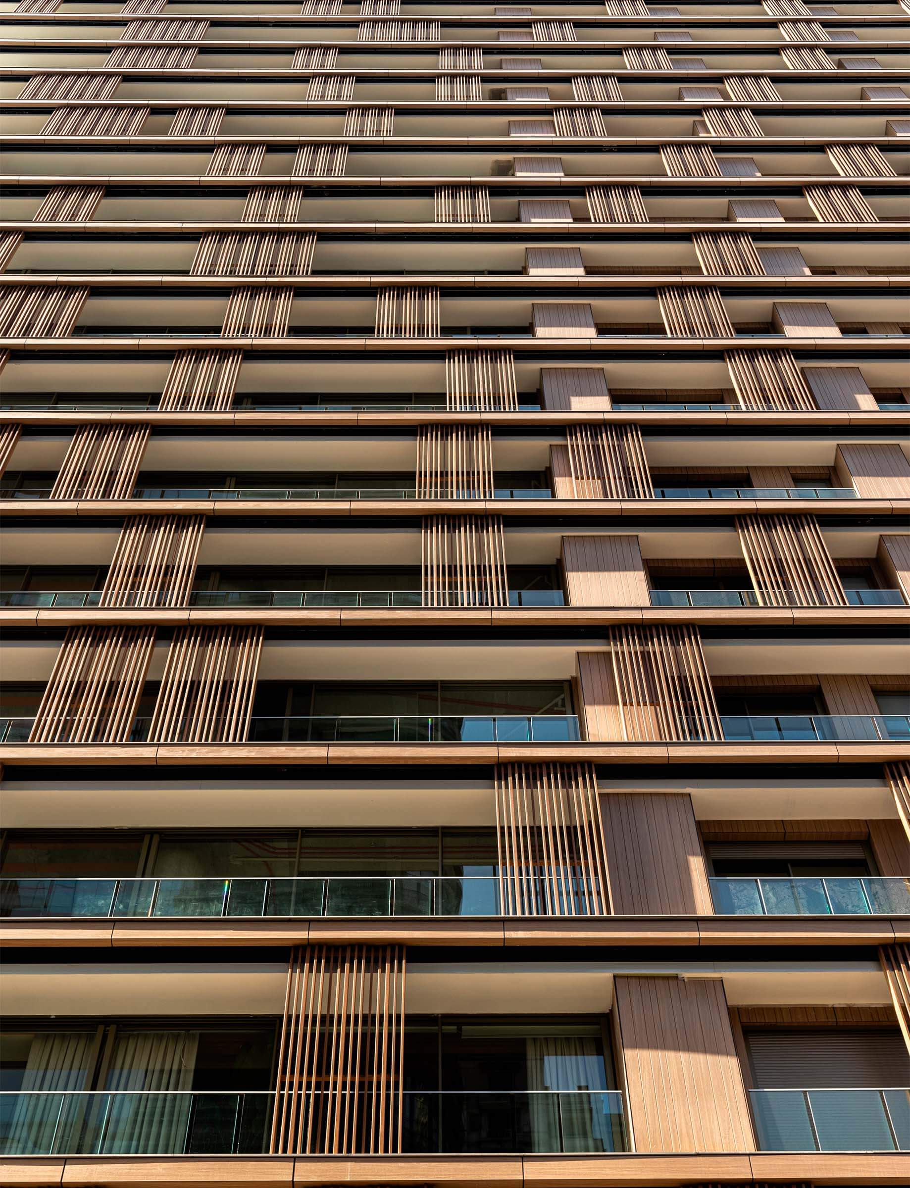 Modern high-rise building with wooden facade elements and glass balconies.