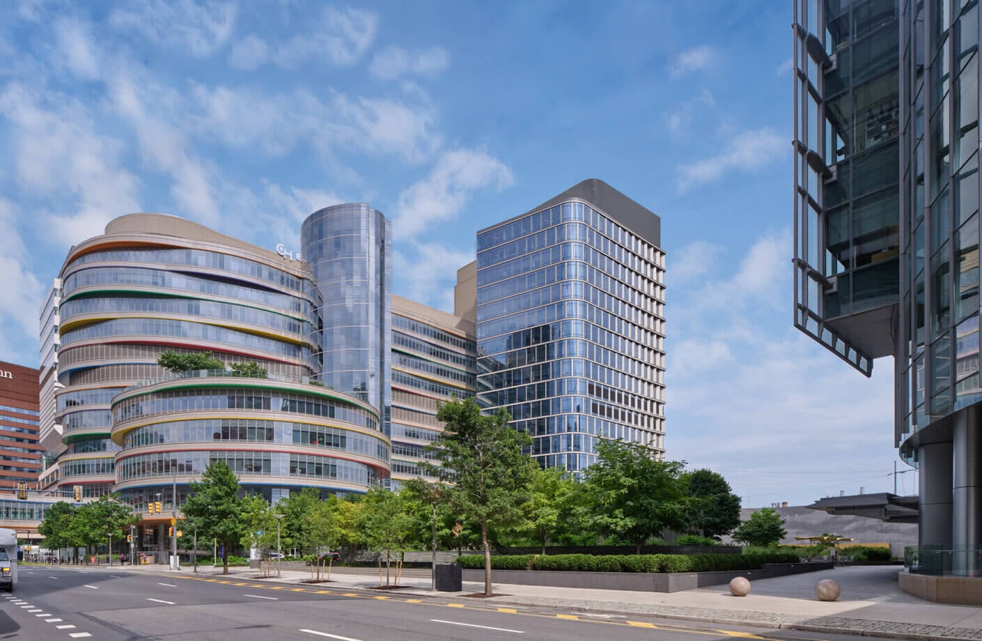 Modern cityscape with colorful, curved buildings and clear blue sky.