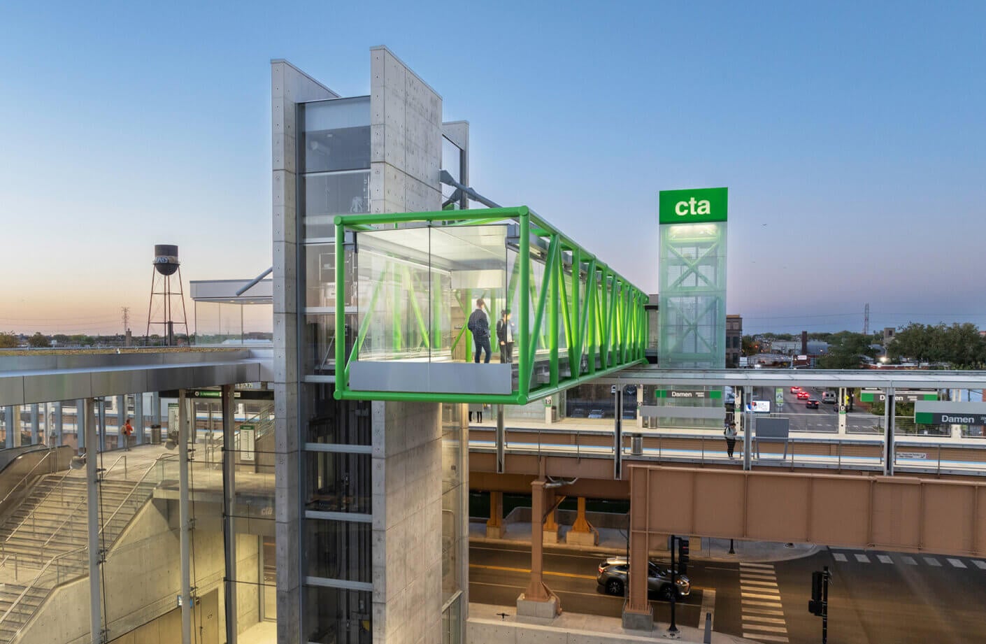 CTA Green Line station with a modern pedestrian bridge at sunset.