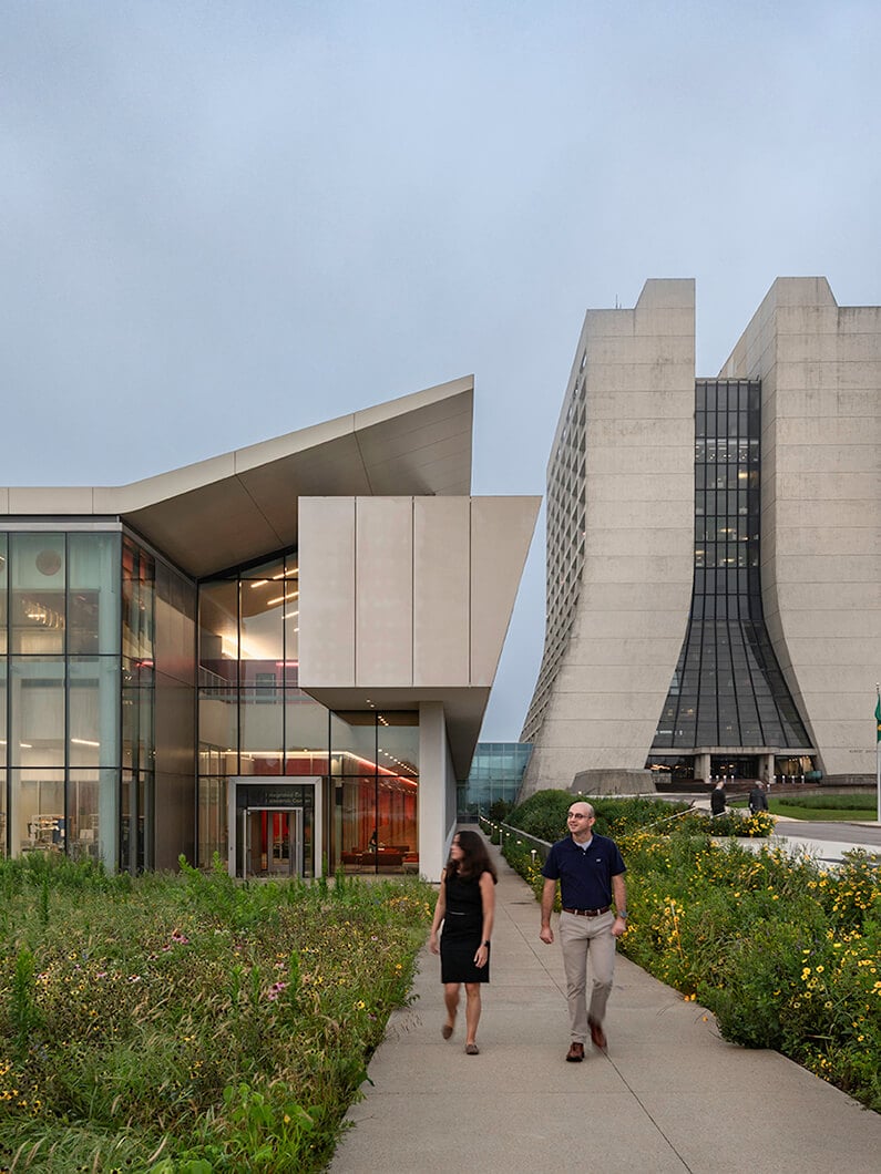 Modern architectural buildings with people walking on a path nearby.