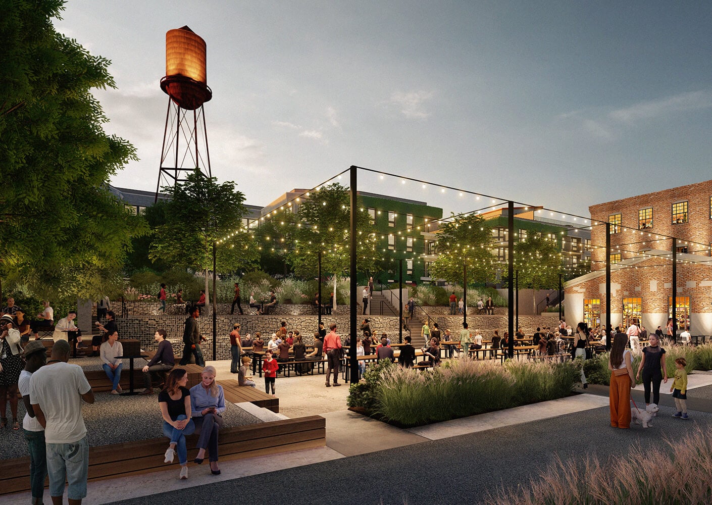 Outdoor dining area with people, string lights, and a water tower at dusk.