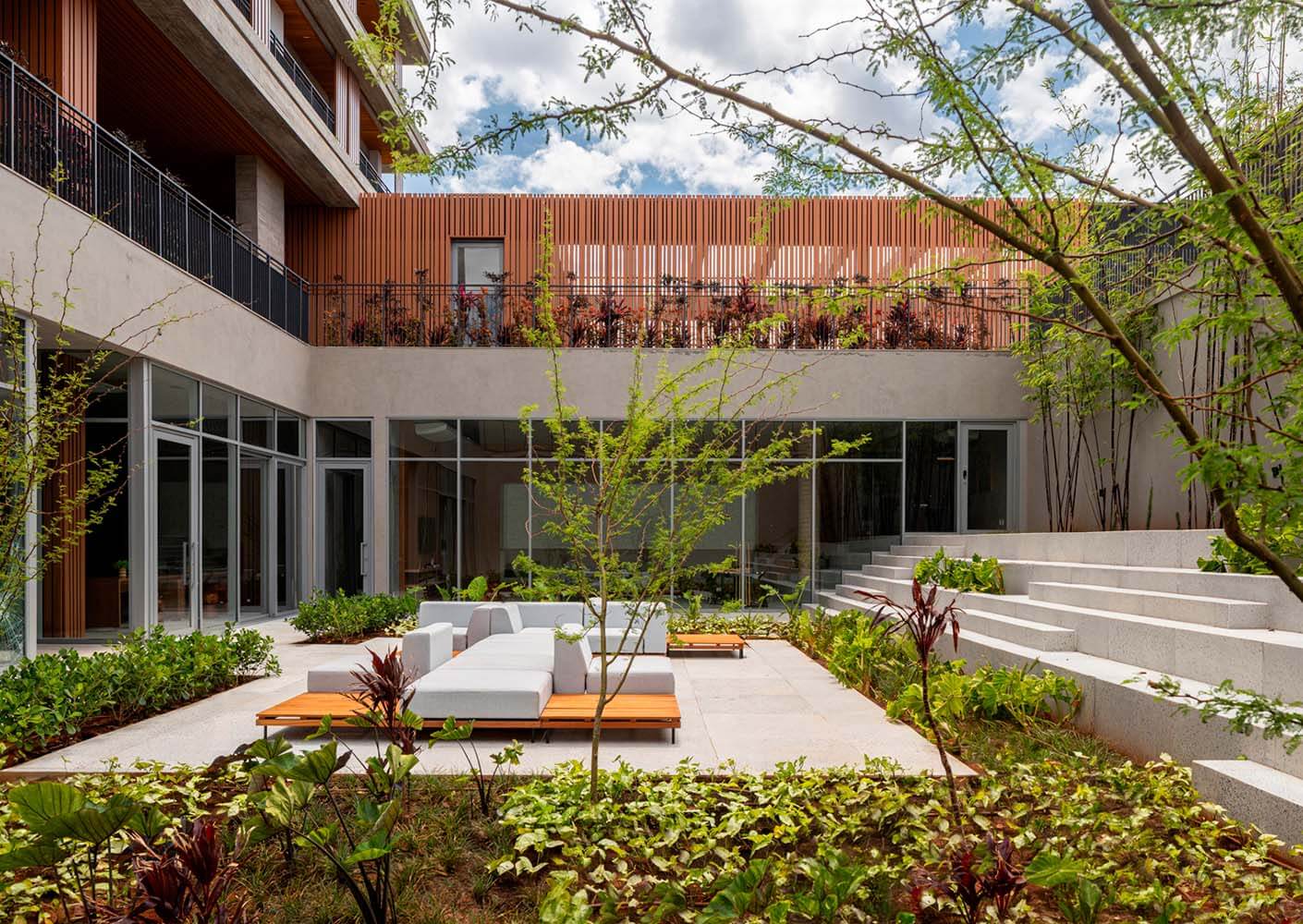 Modern courtyard with lush greenery and stylish patio seating.