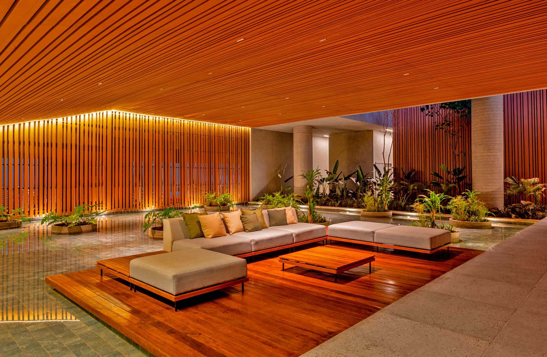 Modern lounge with wooden accents and lush indoor plants.