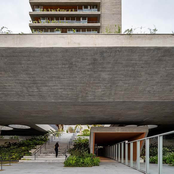 Modern urban architecture with concrete structure and greenery.