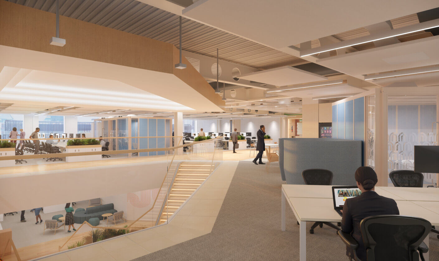 Modern open-plan office workspace with a central staircase and employees working.