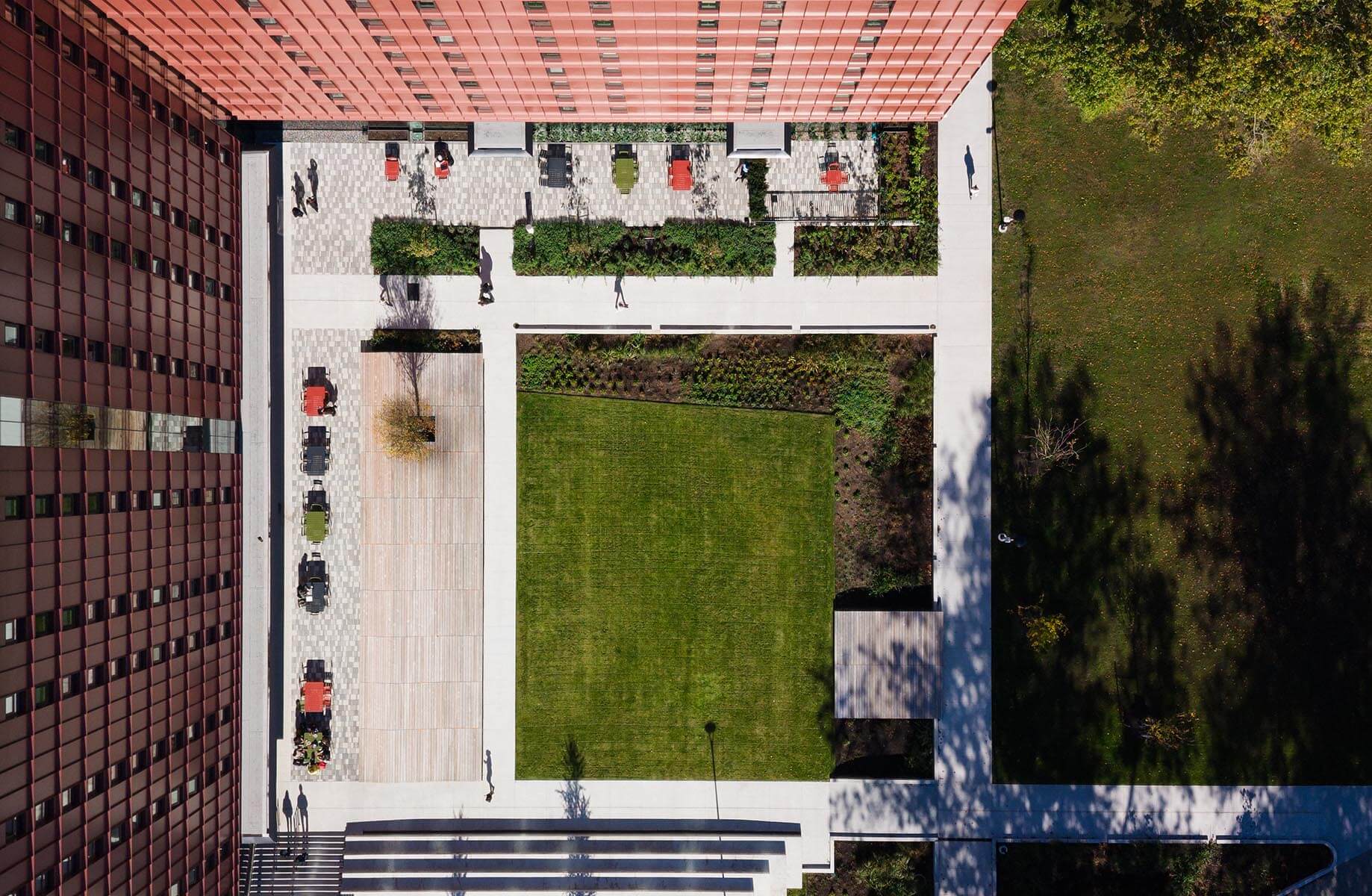 Aerial view of modern urban courtyard with greenery and people.