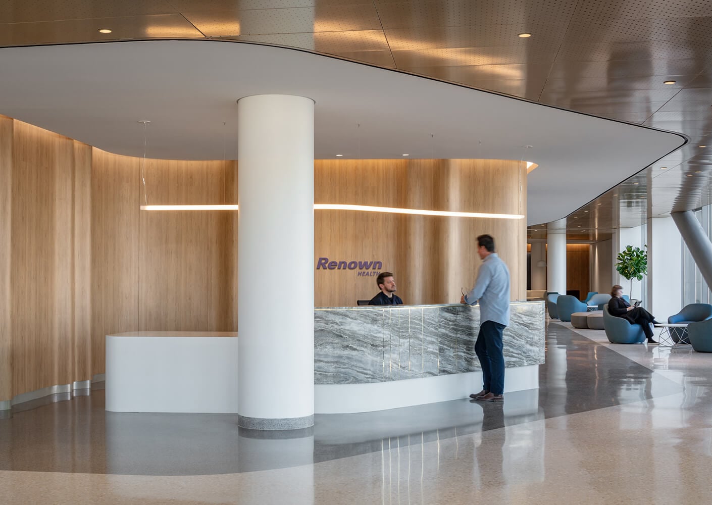 Modern health facility reception with wood accents and marble desk.