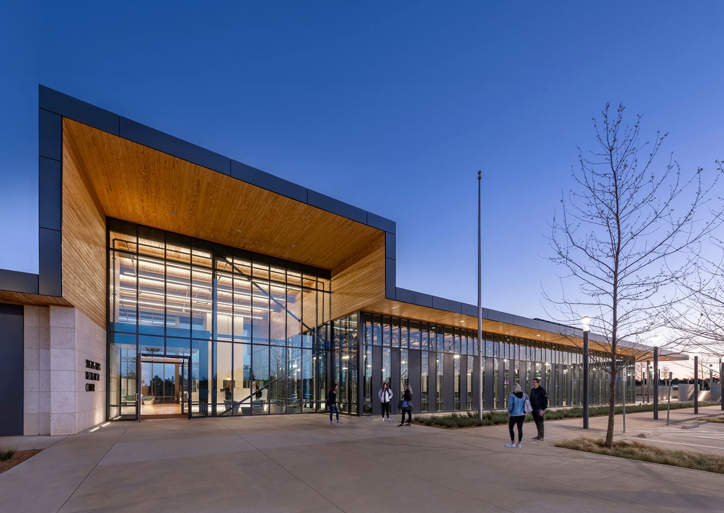 Modern library building with glass facade at dusk.