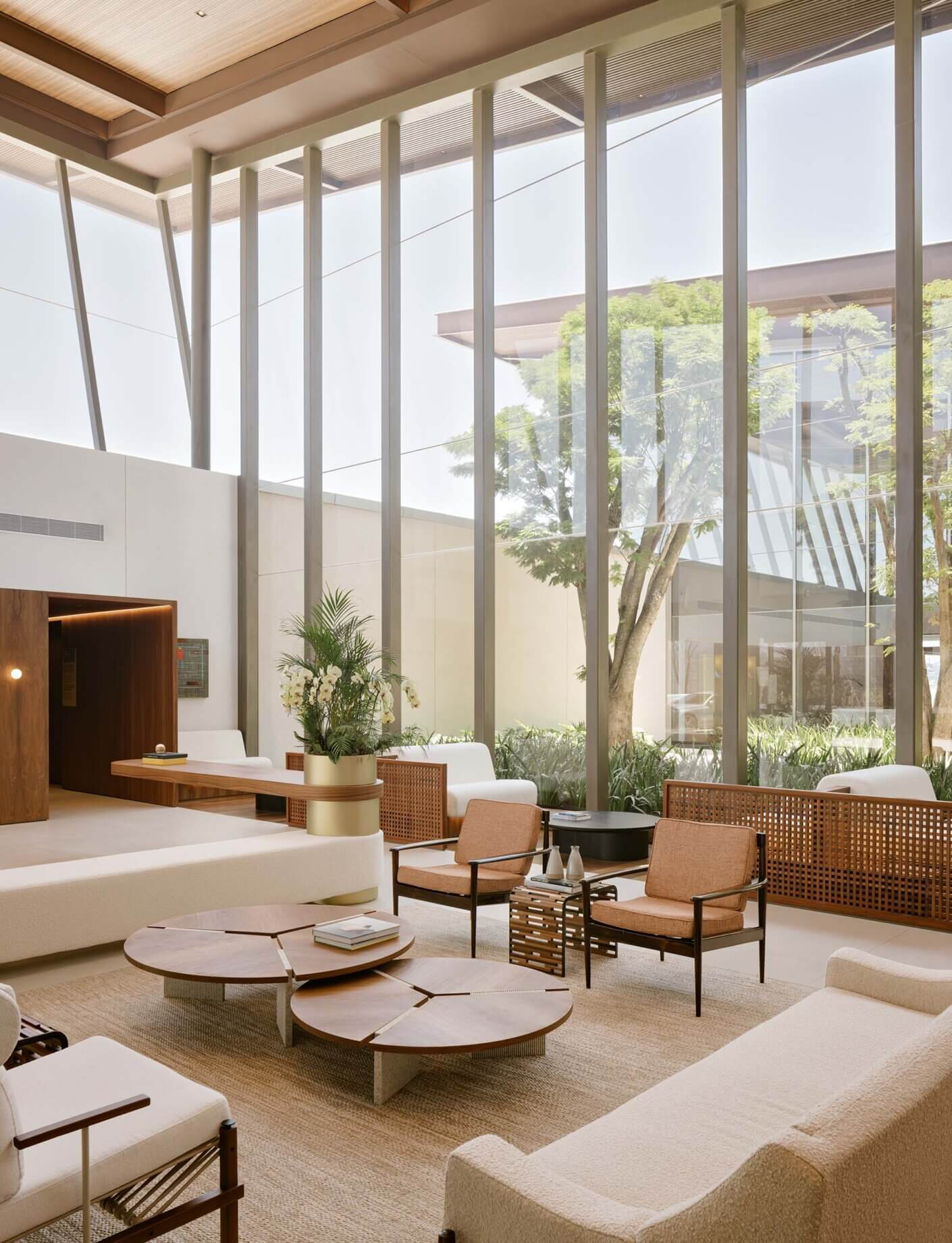 Modern lounge area with large windows, natural light, and minimalist furniture.
