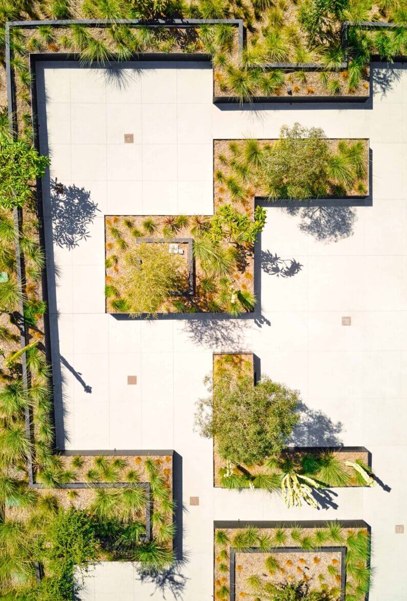 Aerial view of geometric garden design with greenery and pathways.