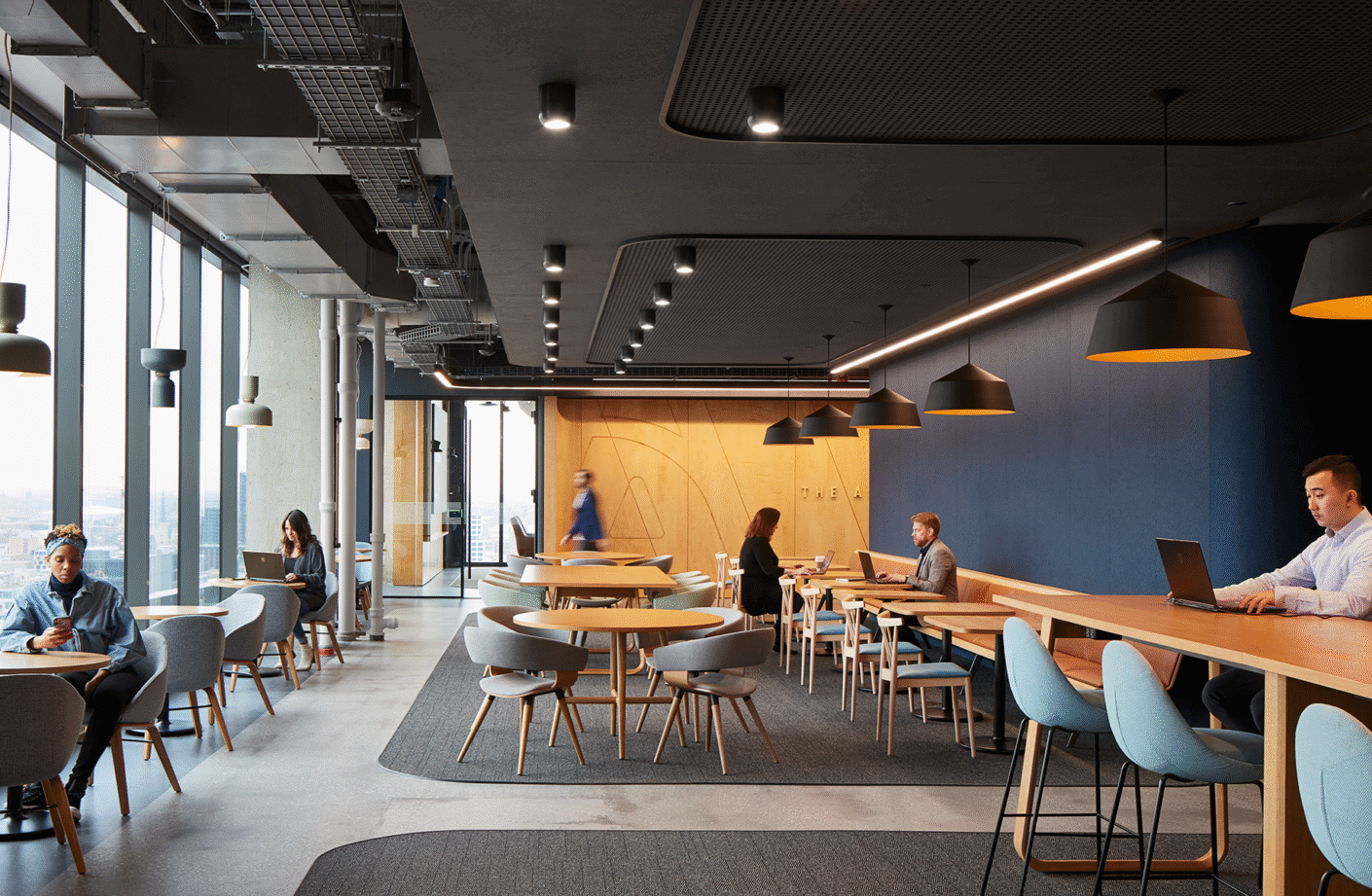 Modern coworking space with people working and networking in an open, stylish environment.