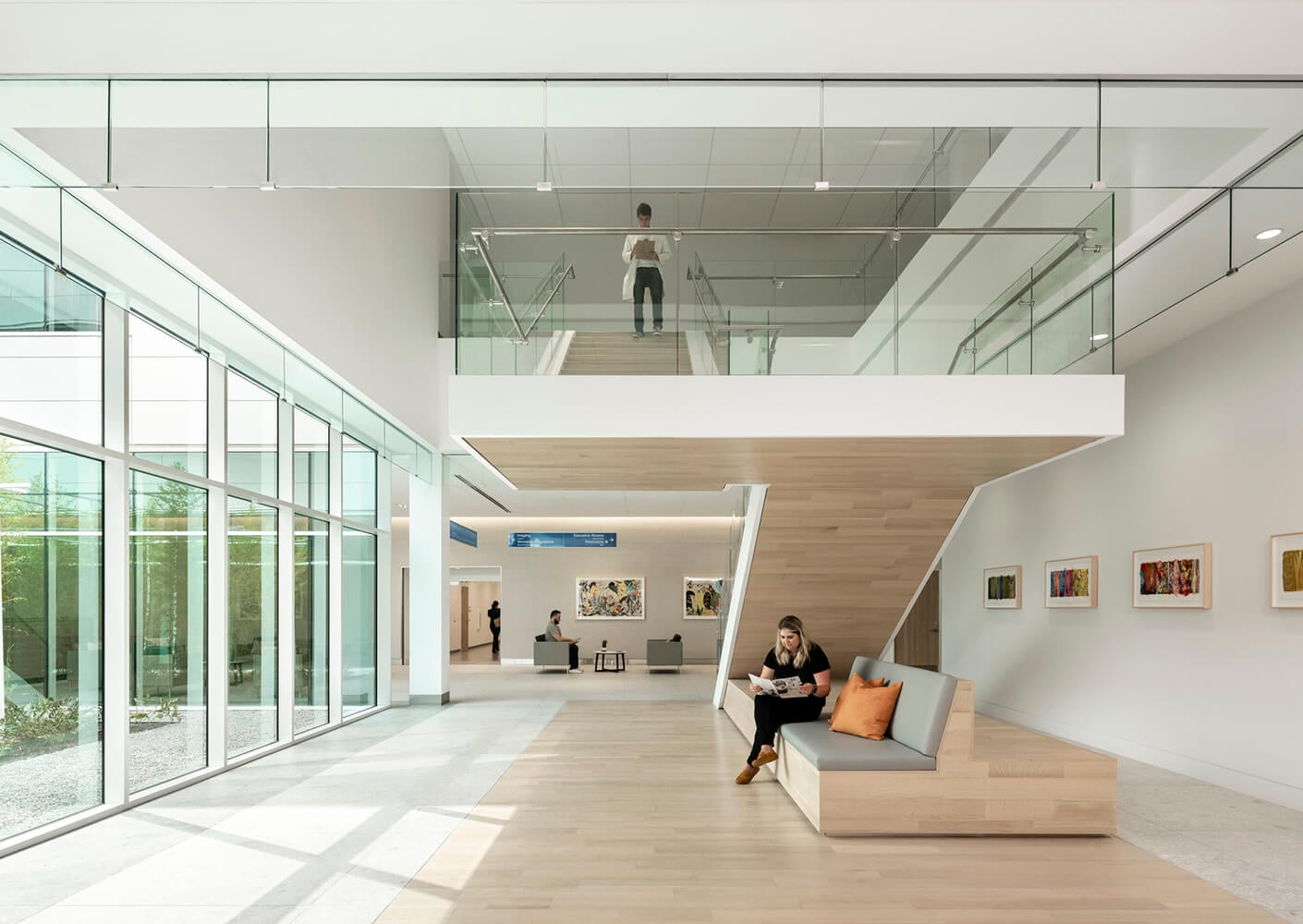 Modern office lobby with glass walls and minimalist seating area.