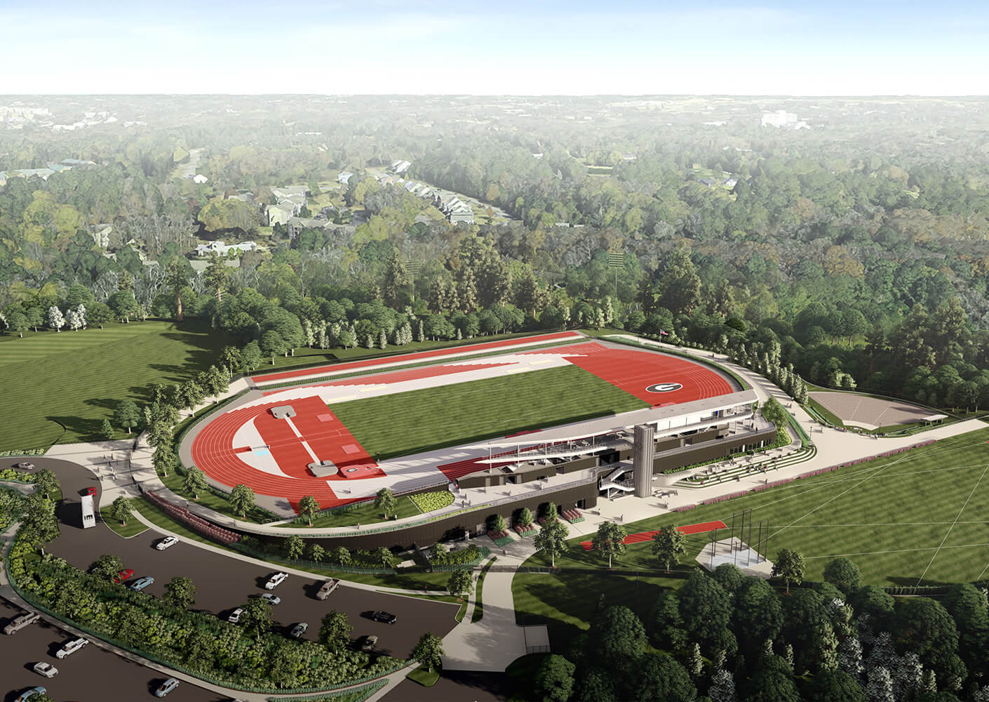 Aerial view of sports stadium with red tracks, surrounded by lush greenery.