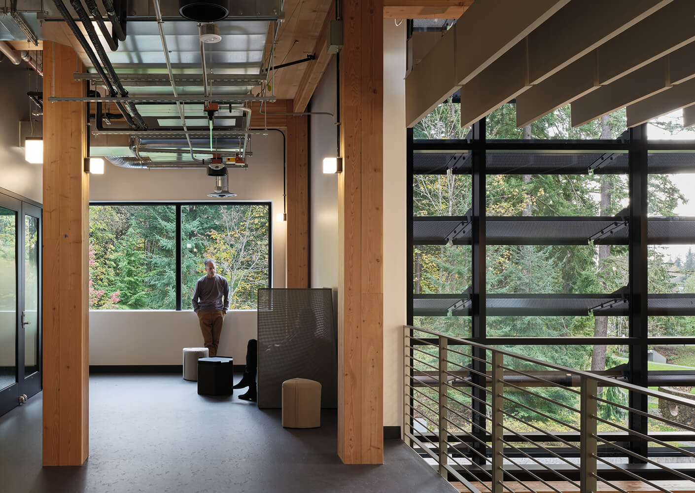 Modern interior with large windows, natural light, and view of forest trees.
