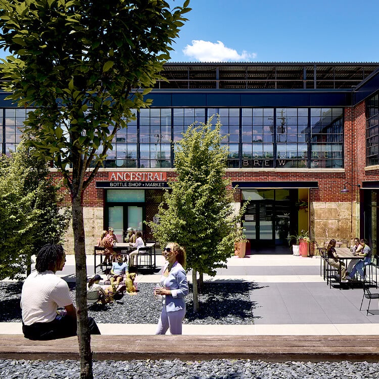 Modern brewery outdoor seating with people enjoying a sunny day.