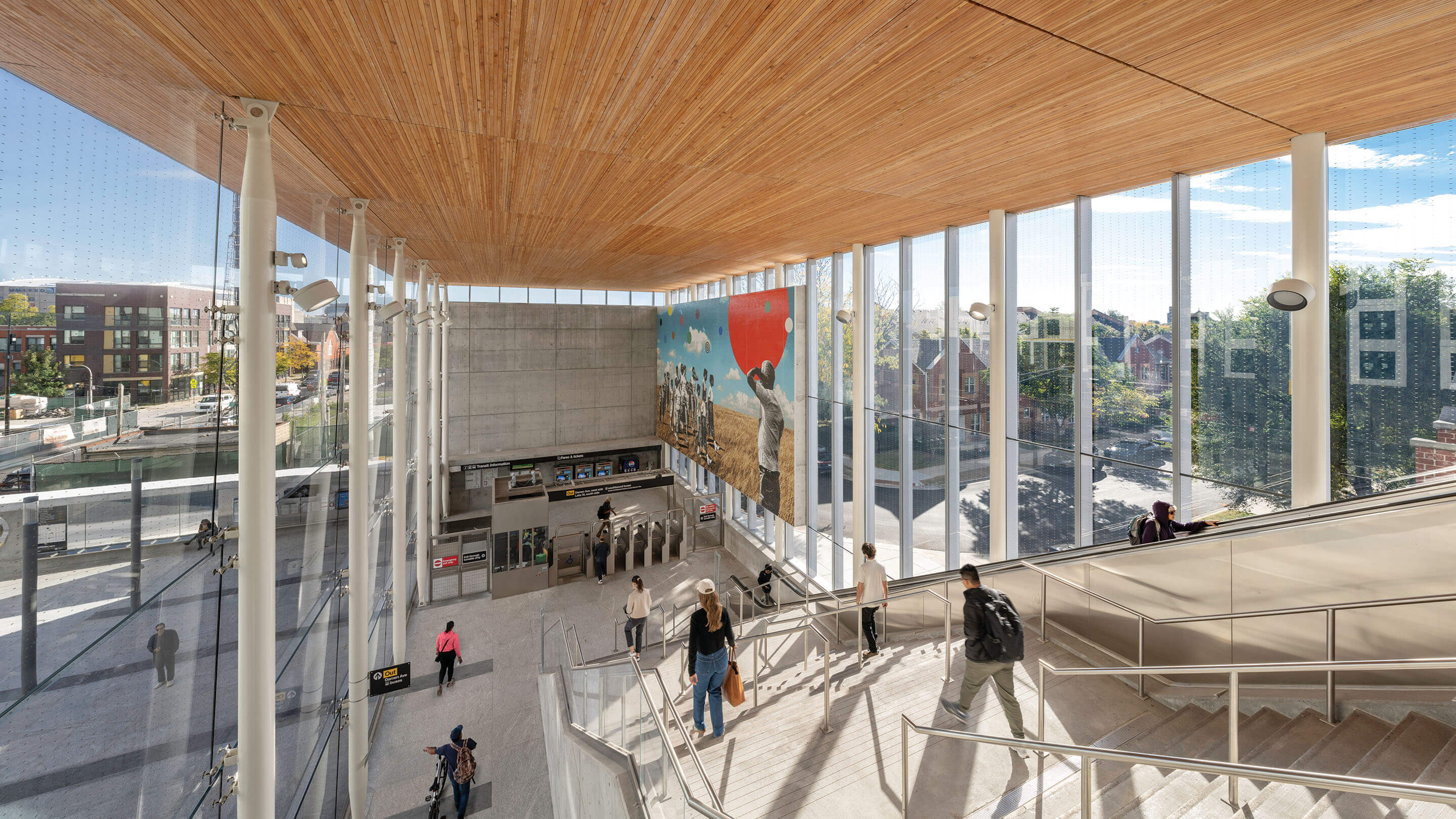 Modern transit station interior with wooden ceiling and large windows.