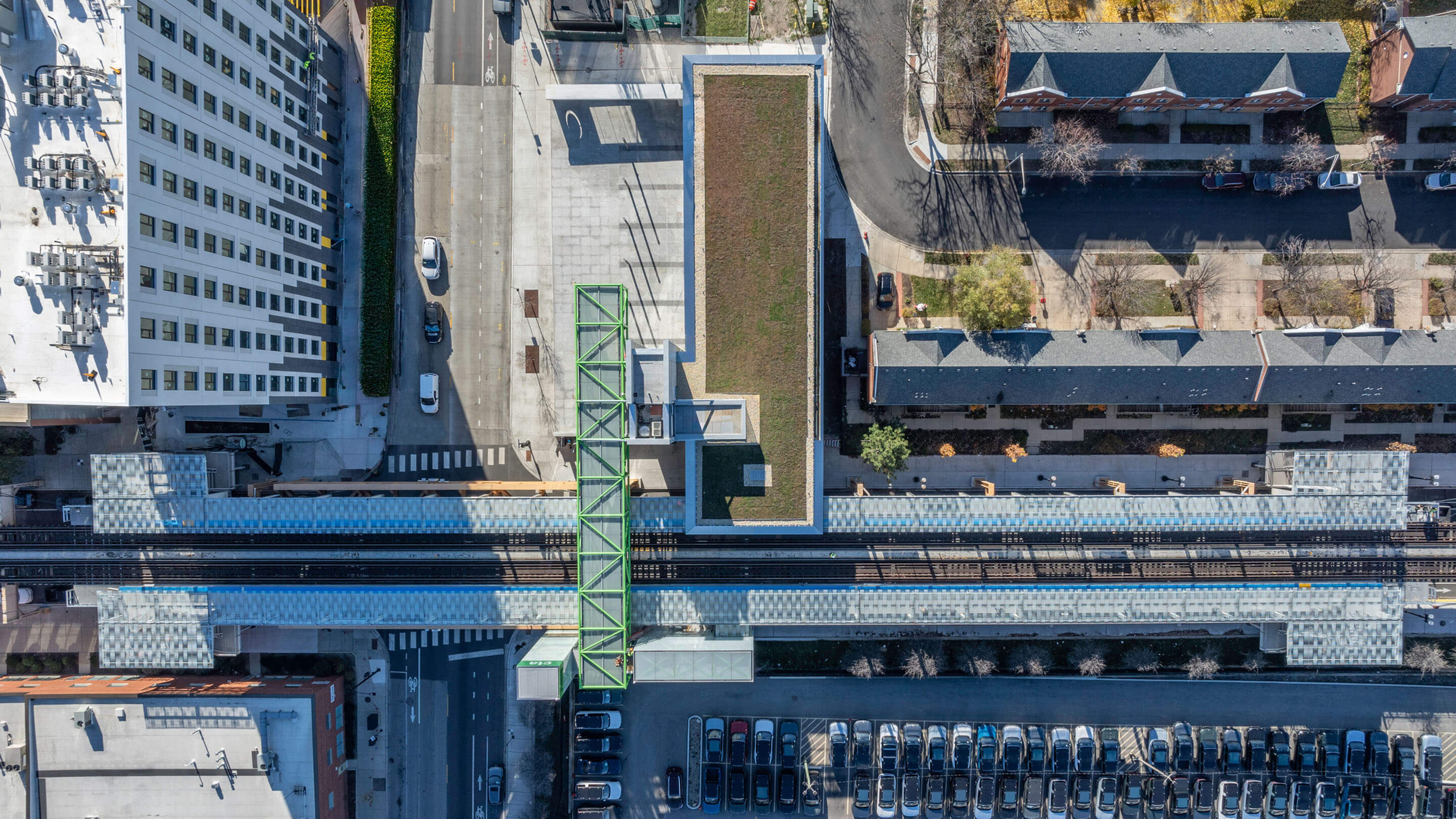 Aerial view of urban train station and surrounding cityscape.