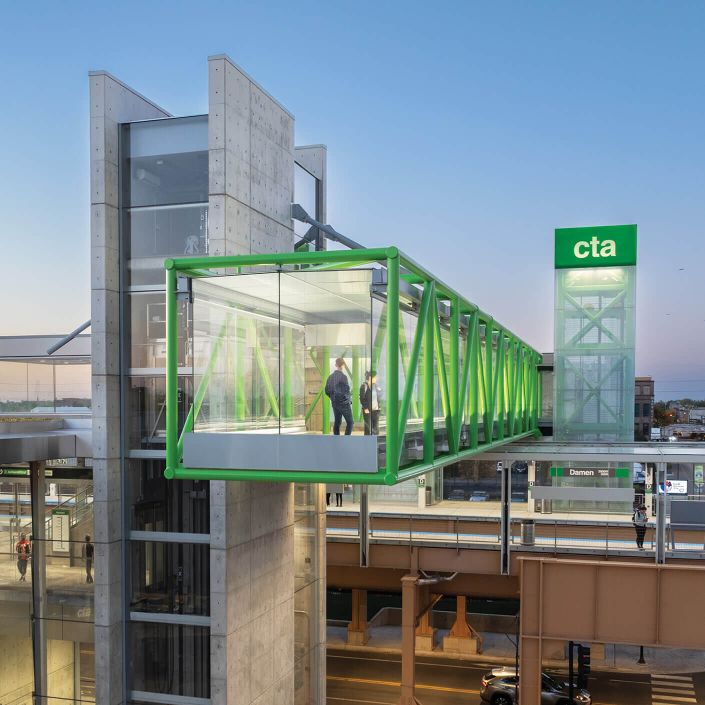 Modern public transit station with glass walkway and green structural details