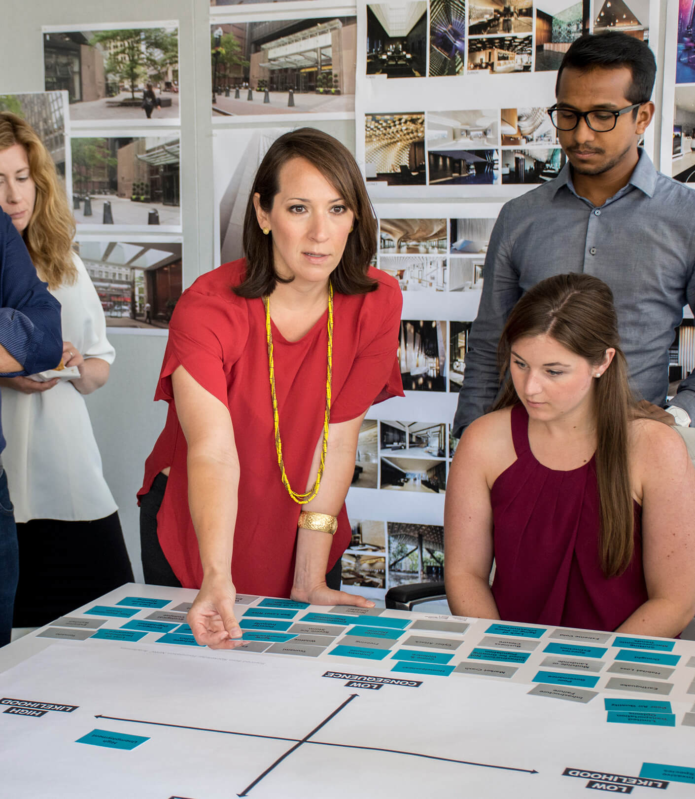 Yanel de Angel and team collaborating on design project with boards in background.