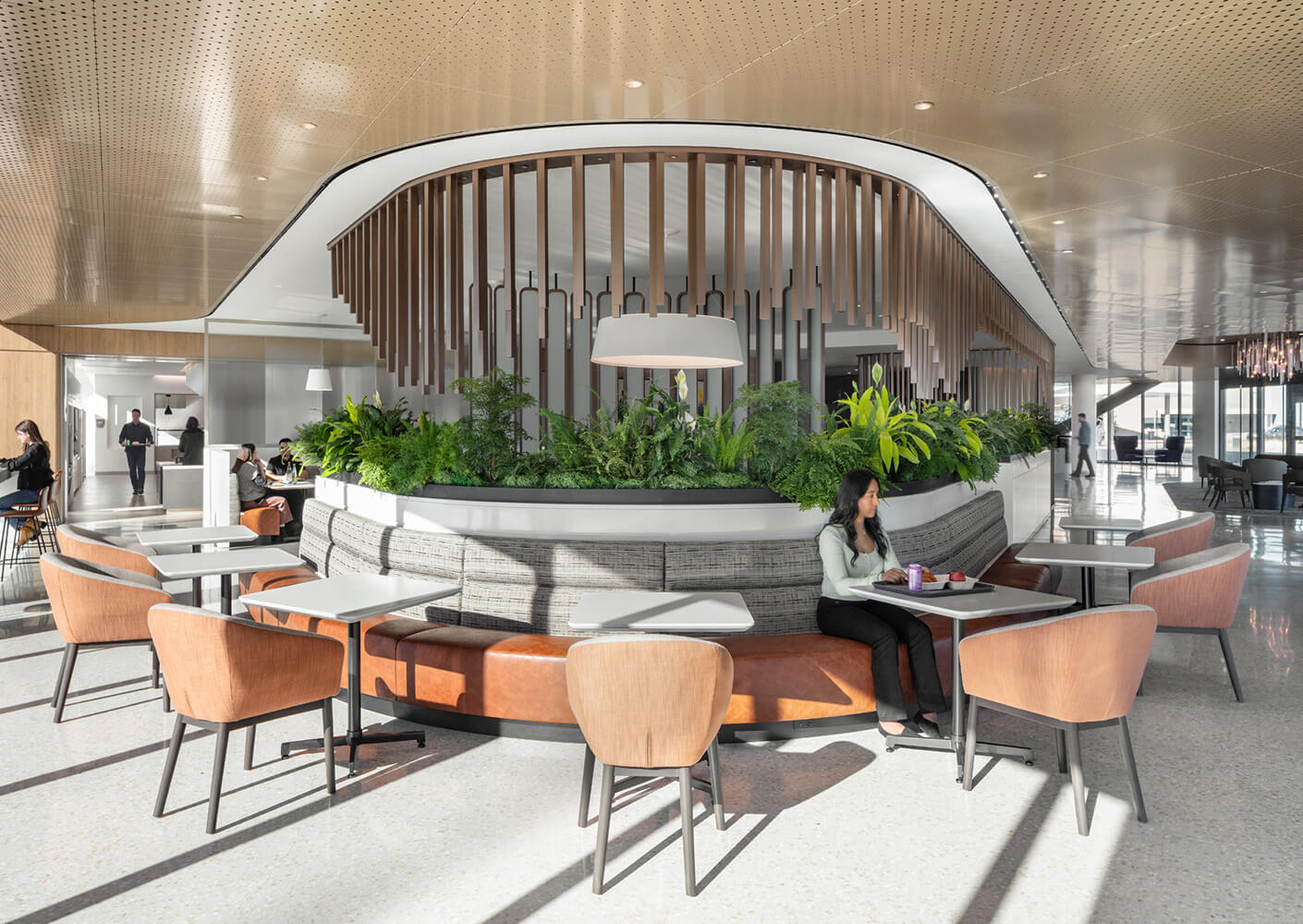 Modern lounge with seating, greenery, and natural light.