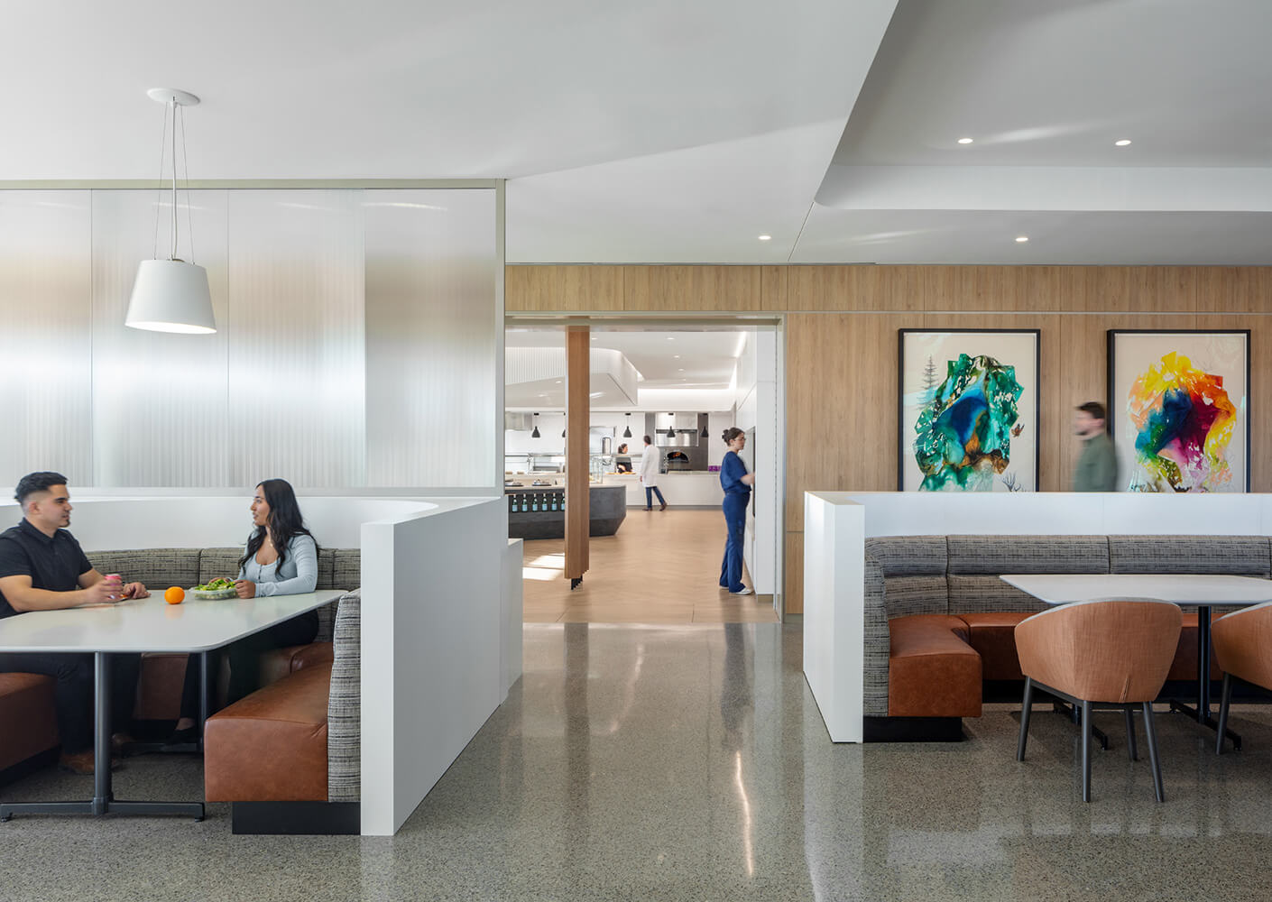Modern cafeteria with seating booths and colorful wall art.