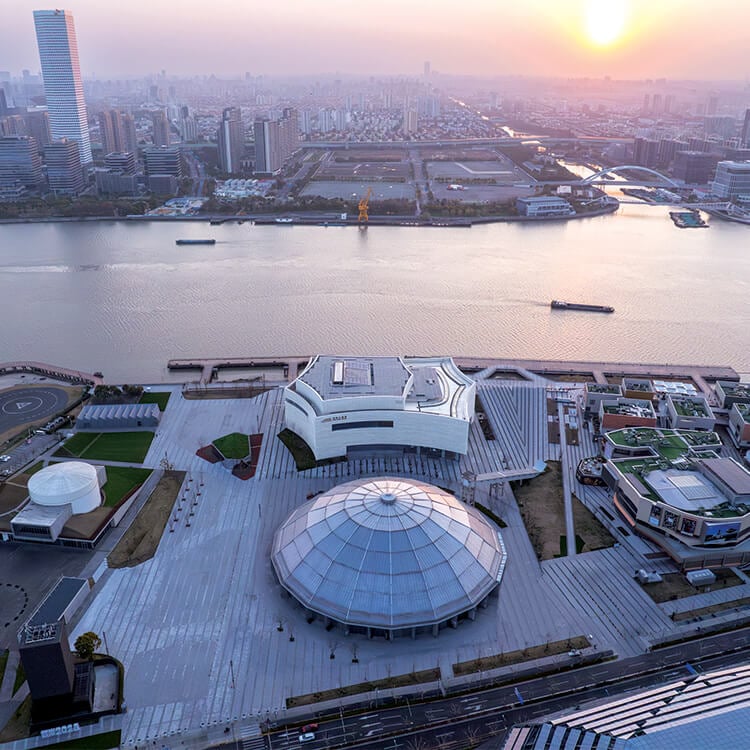Aerial view of a waterfront modern architectural complex near a river.