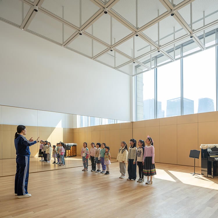 Children's choir practice in a bright, modern rehearsal room.