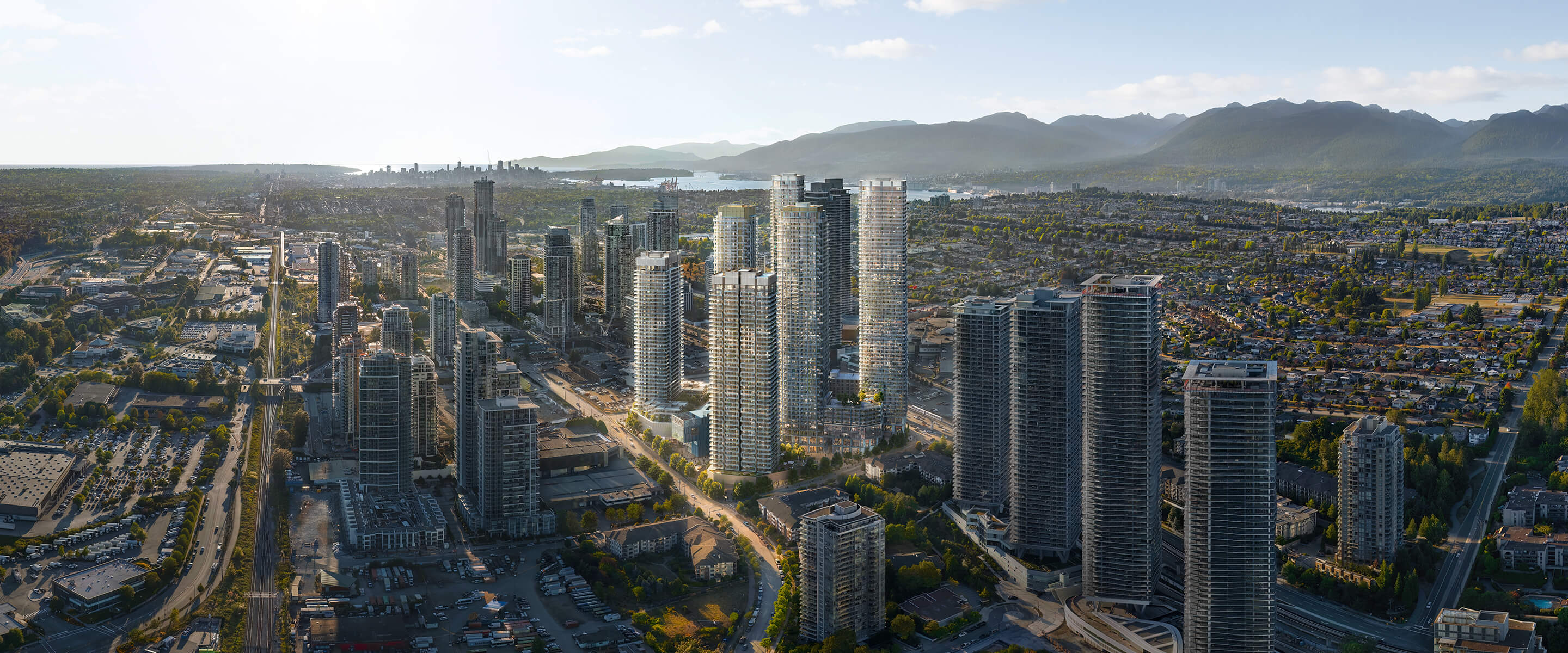Aerial view of a cityscape with mountains in the background and tall skyscrapers.
