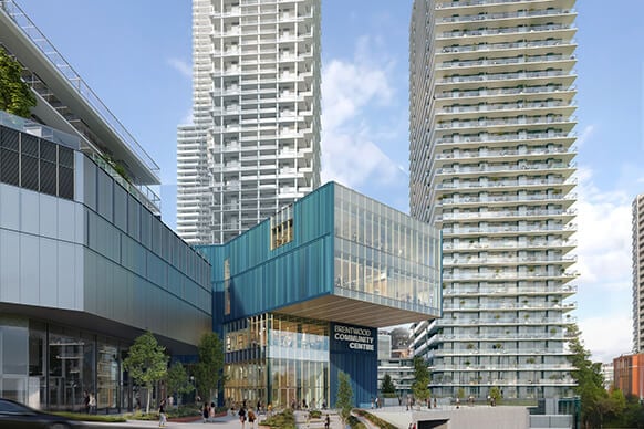 Modern community center between high-rise buildings in urban setting.