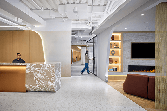Modern office lobby with a marble reception desk and elegant decor.