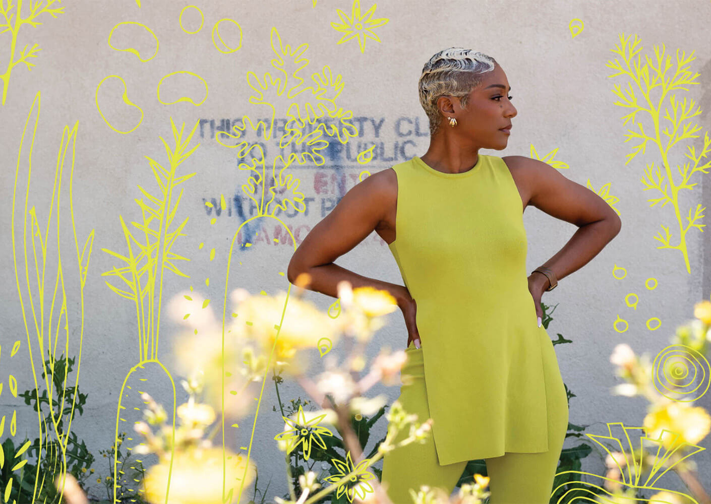 Person in vibrant yellow outfit with floral graphics on the wall.