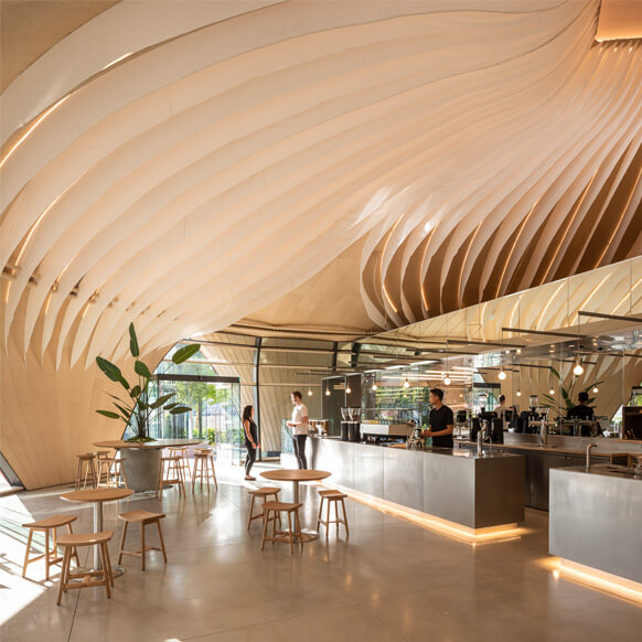 Modern cafe interior with unique wavy ceiling design and minimalist decor.