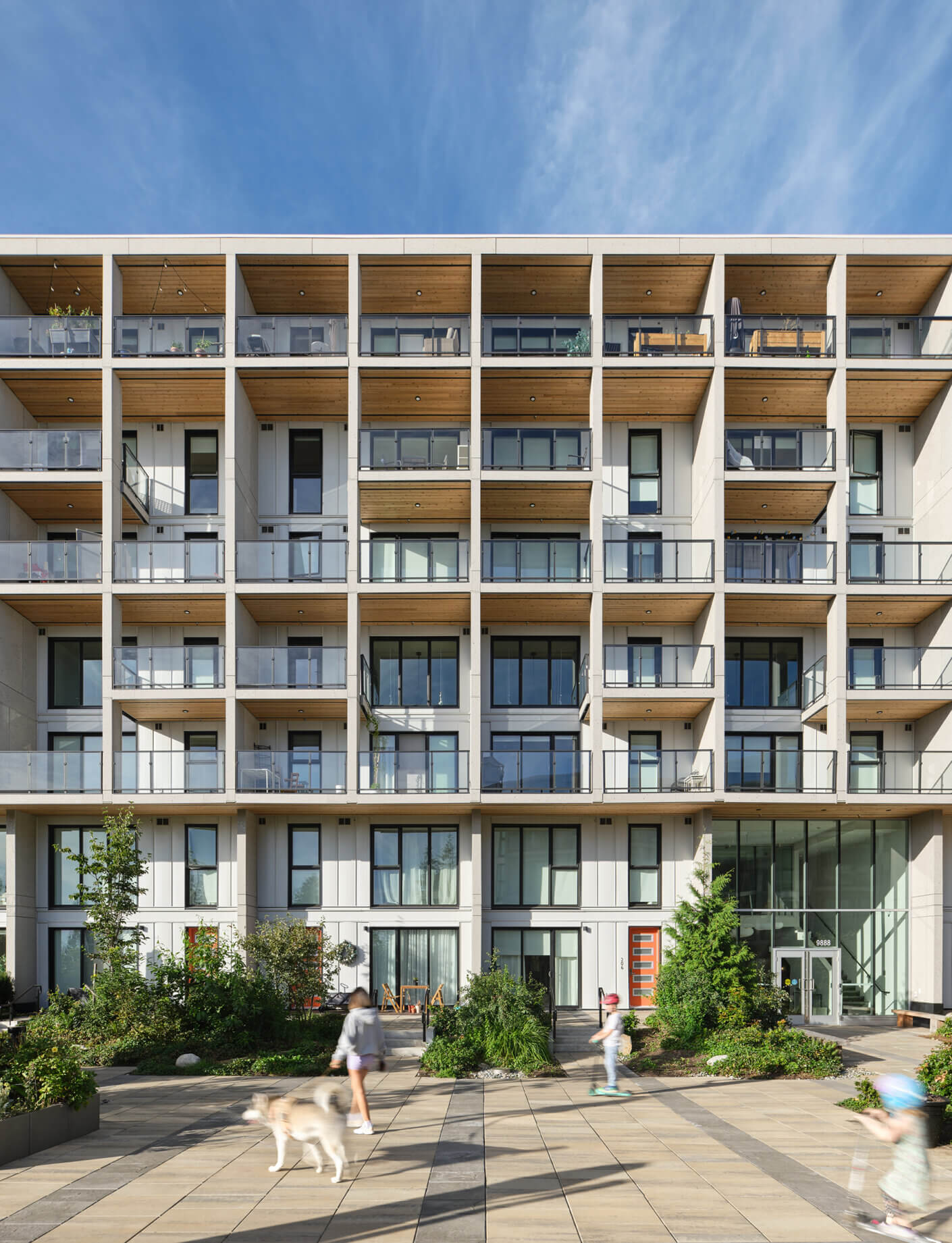 Modern apartment building with balconies and people in the foreground.