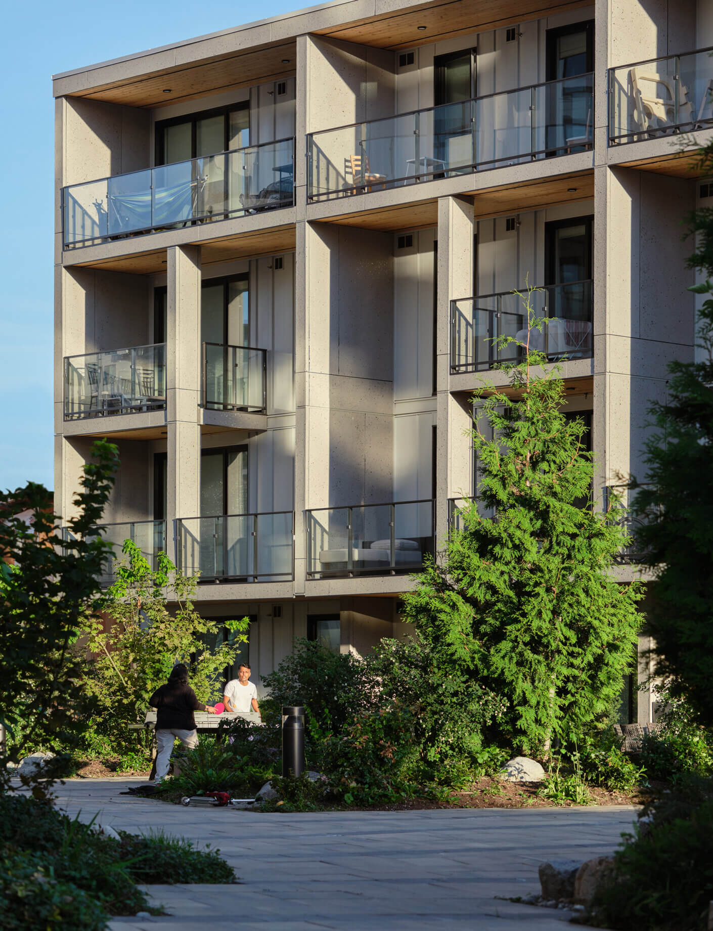Modern apartment building with balconies and lush green landscaping.